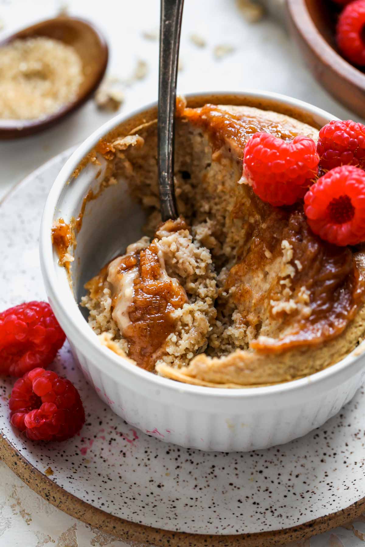 A spoon digging into a ramekin of baked oats for one