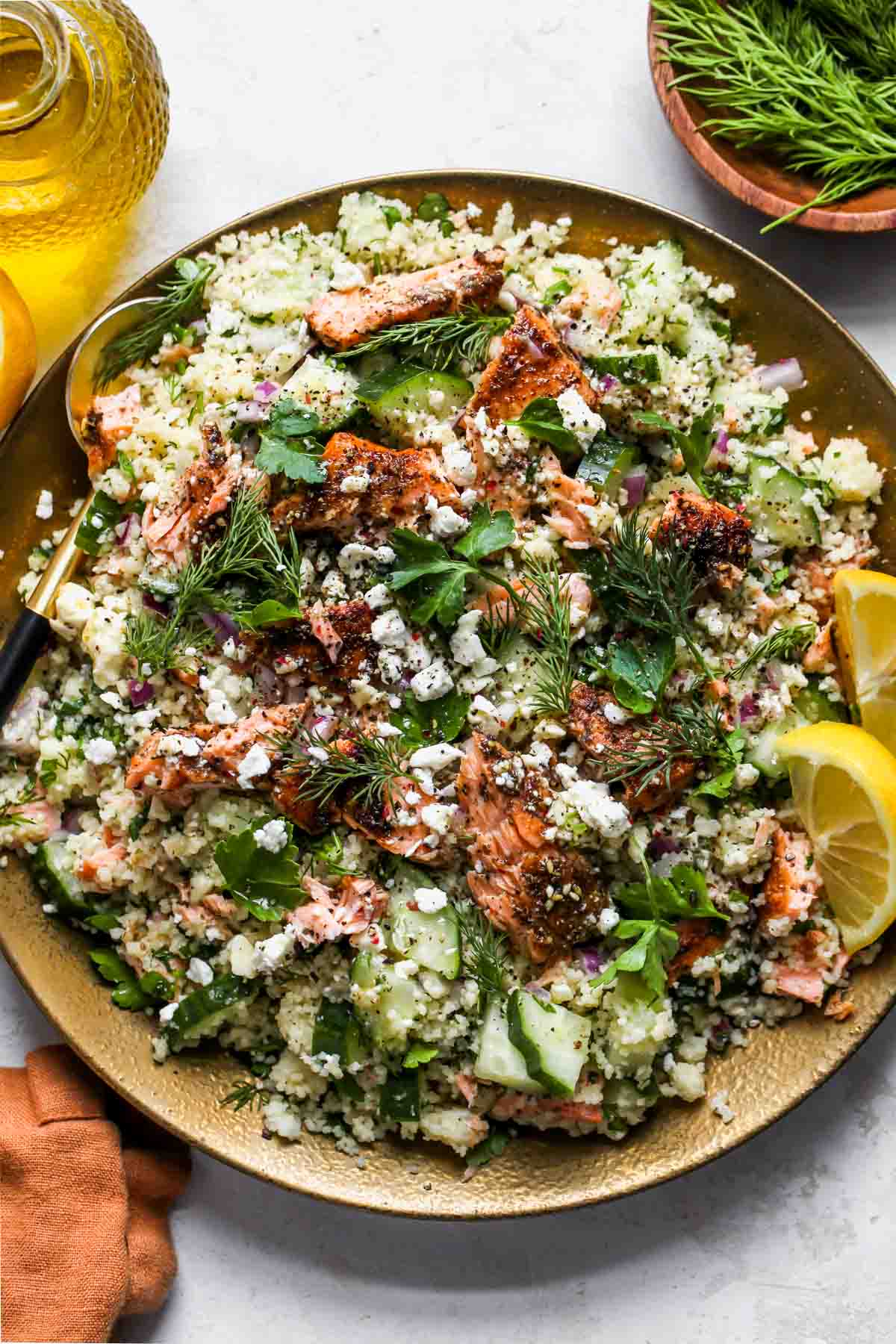 Salmon couscous salad assembled on a gold serving plate.
