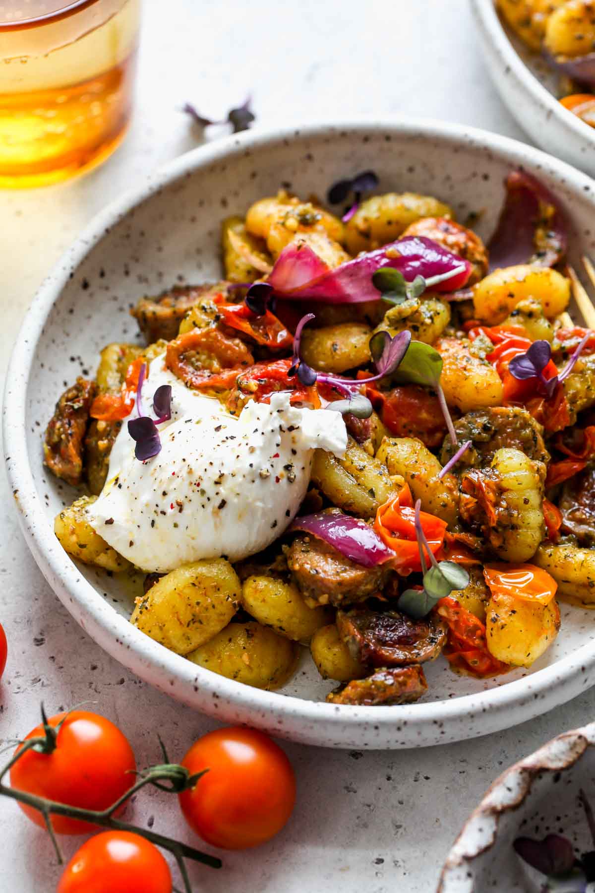 White serving bowls filled with sheet pan gnocchi and veggies