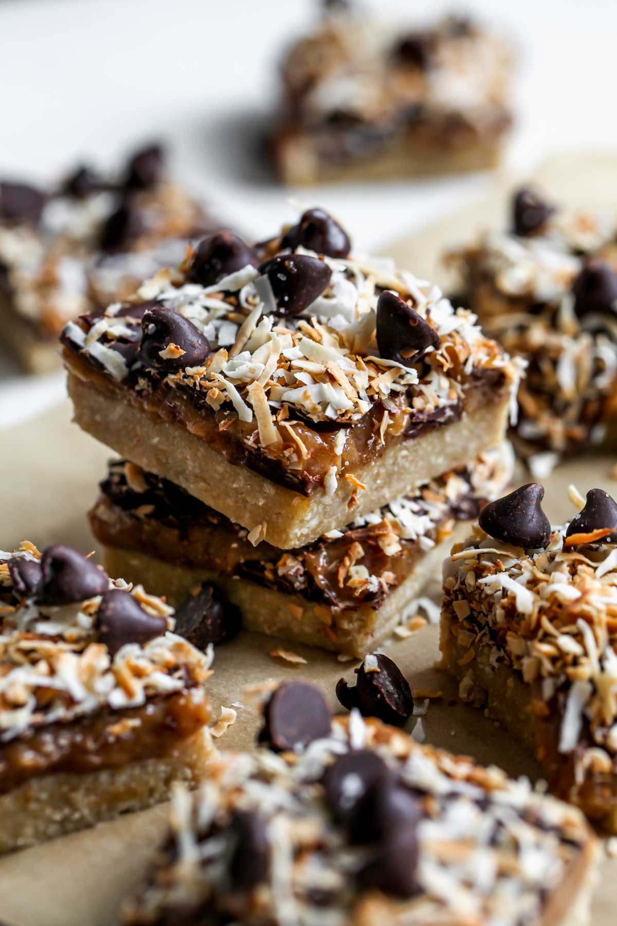 Vegan magic bars stacked on a piece of parchment paper