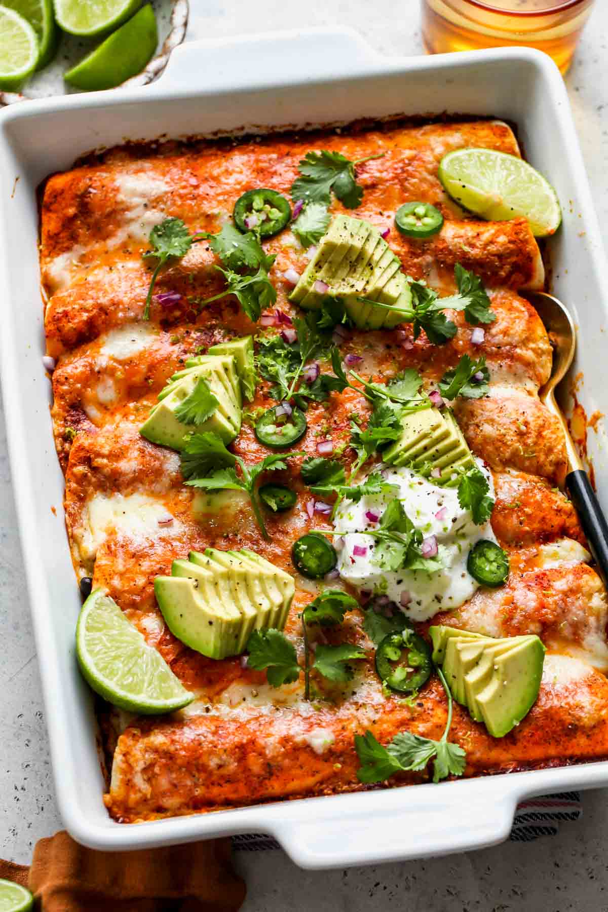 Pan of veggie enchiladas baked and topped with garnishes