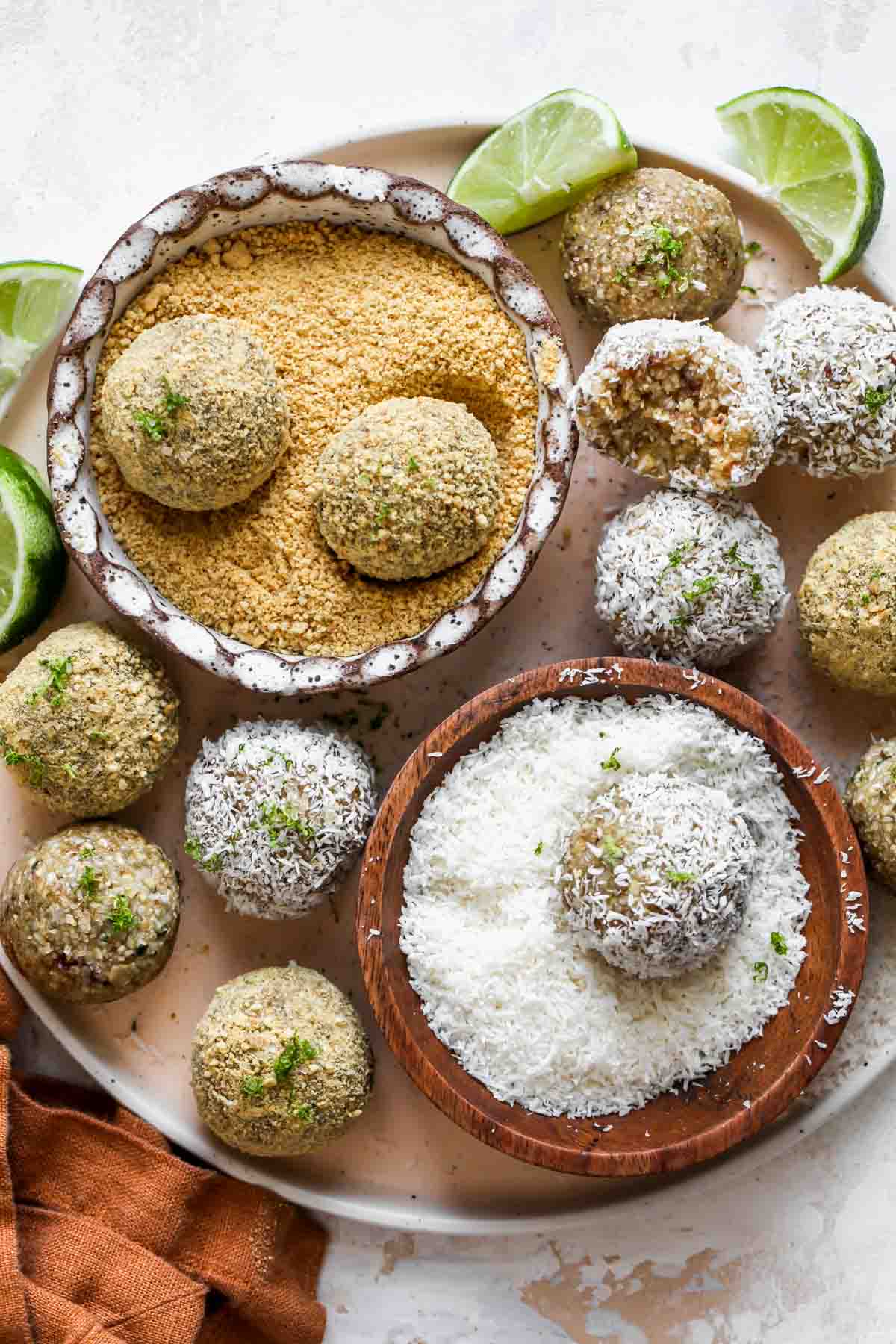 Key lime energy balls on a plate with shredded coconut and graham cracker crumbs