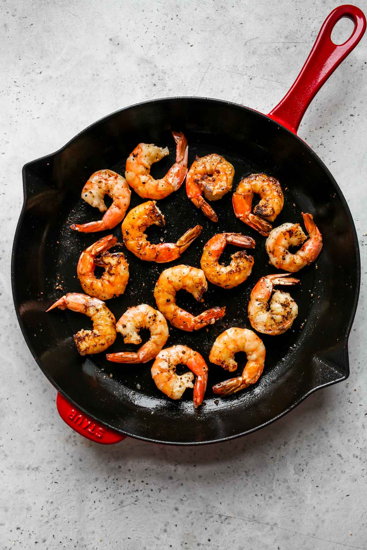 Shrimp sautéing in a cast iron skillet.