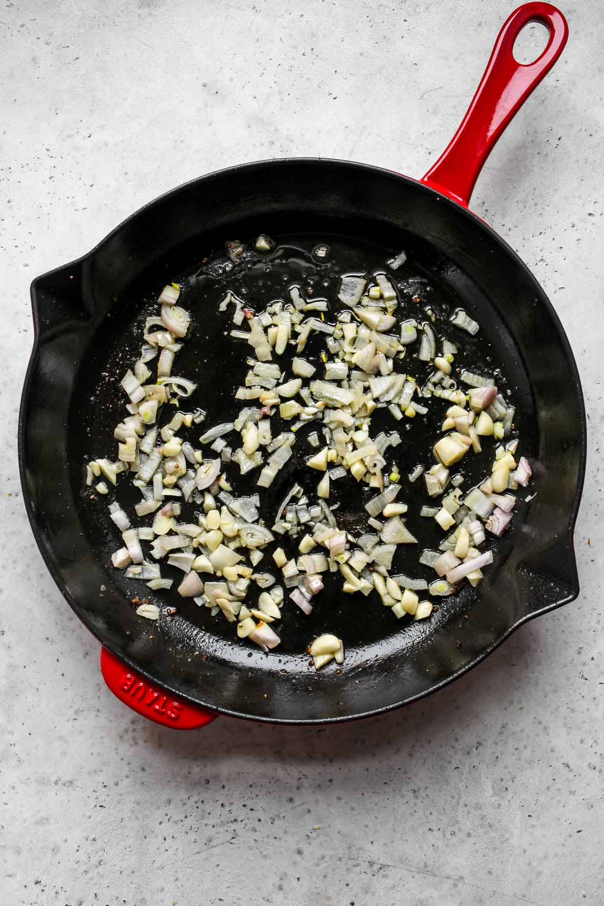 Shallots and garlic sautéing in a skillet.