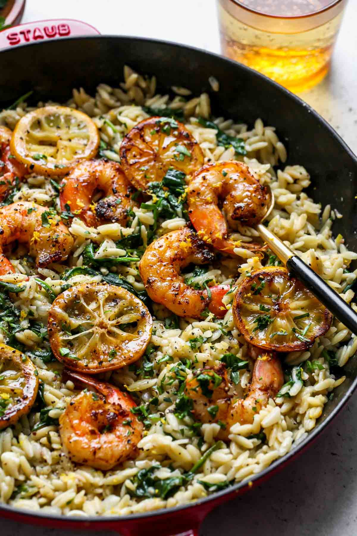 Shrimp, spinach, lemon, and orzo in a skillet for an easy spring dinner recipe.