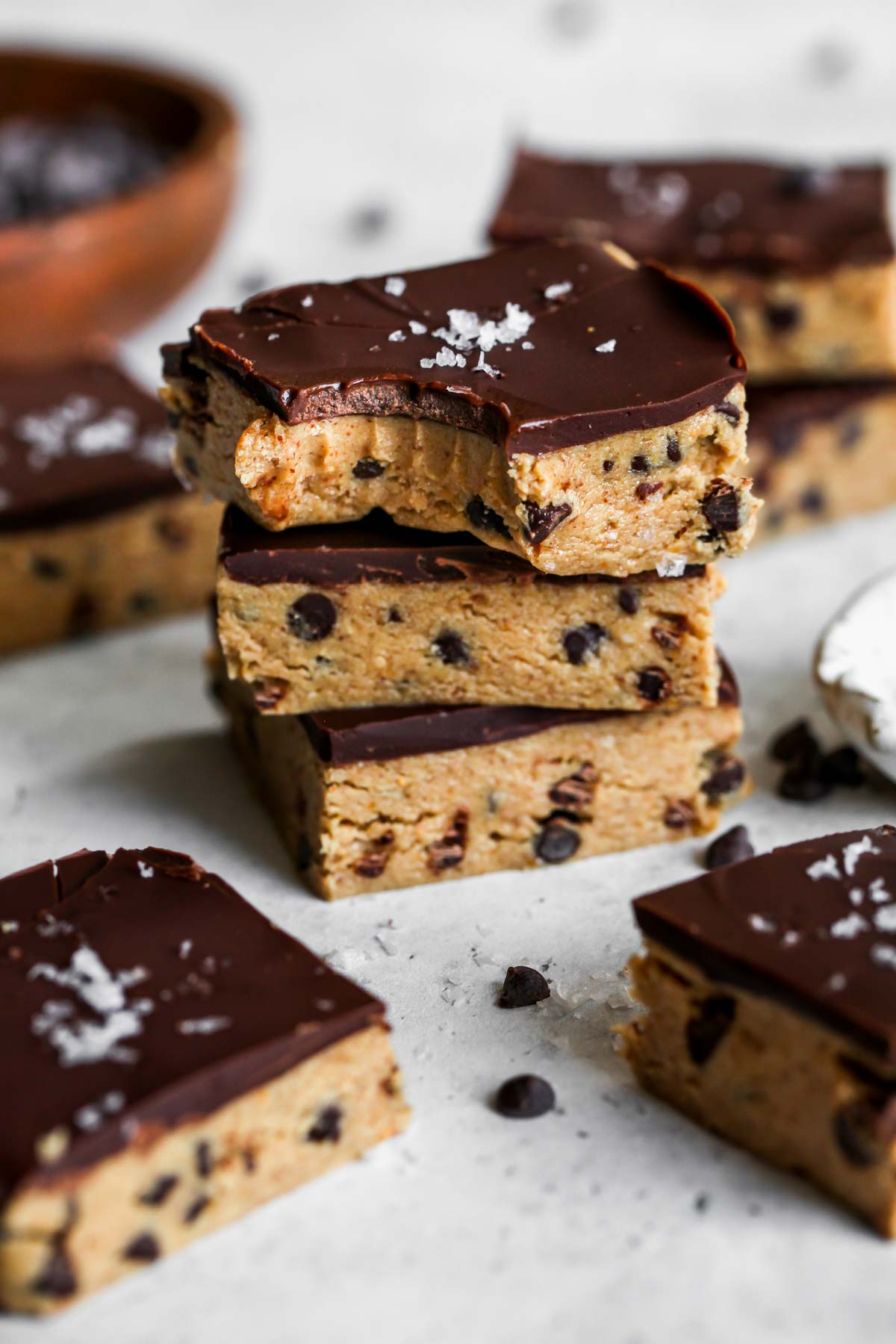 Peanut butter chocolate protein bars stacked on top of one another with a bite taken out
