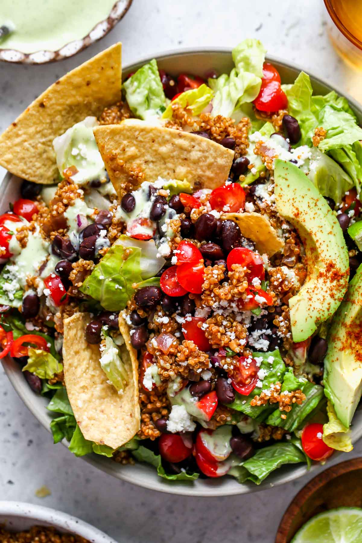 Assembled vegetarian taco salad in a bowl topped with dressing and avocado