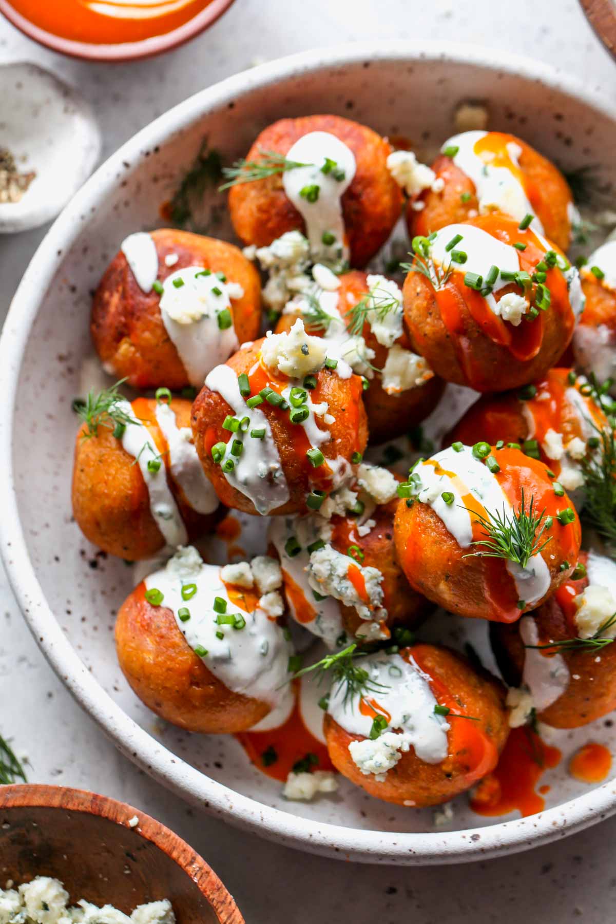 Buffalo chickpea meatballs stacked in a bowl drizzled with ranch