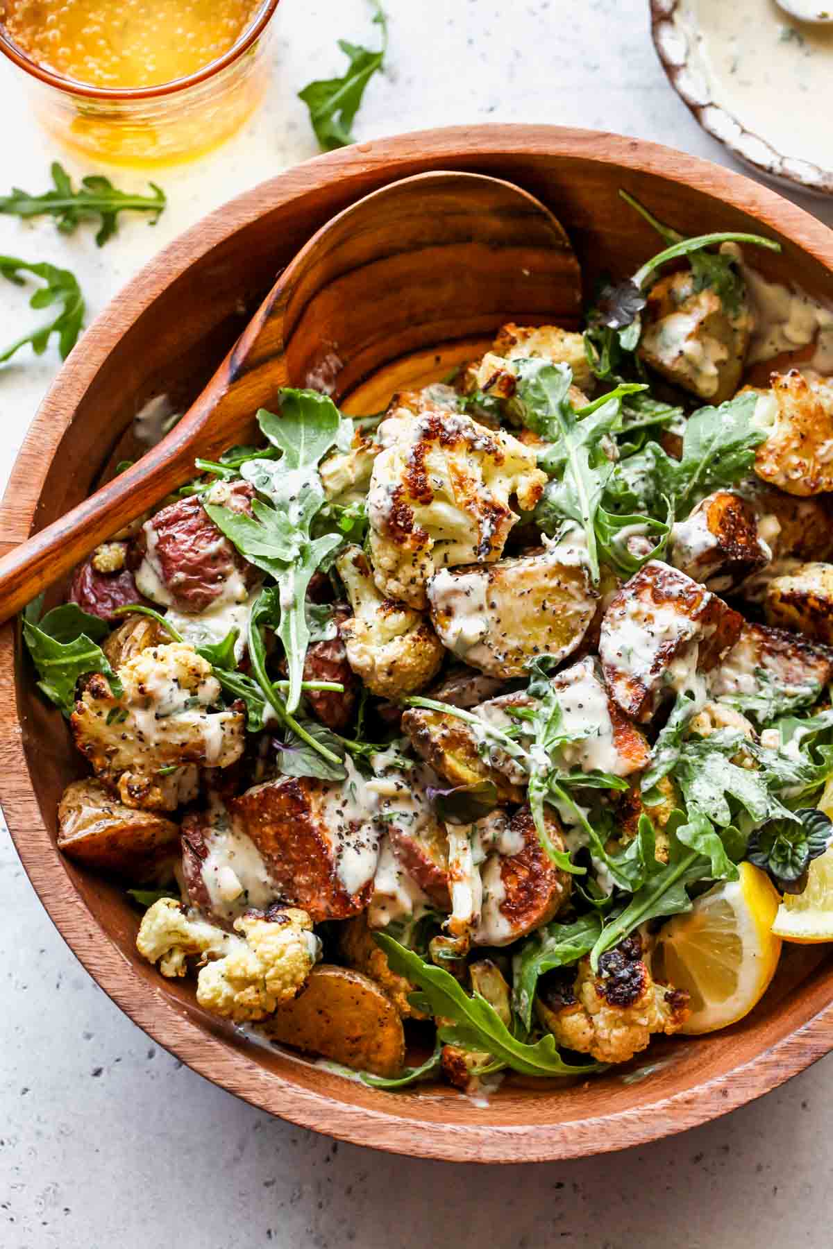 Cauliflower potato salad in a serving bowl tossed with tahini dressing