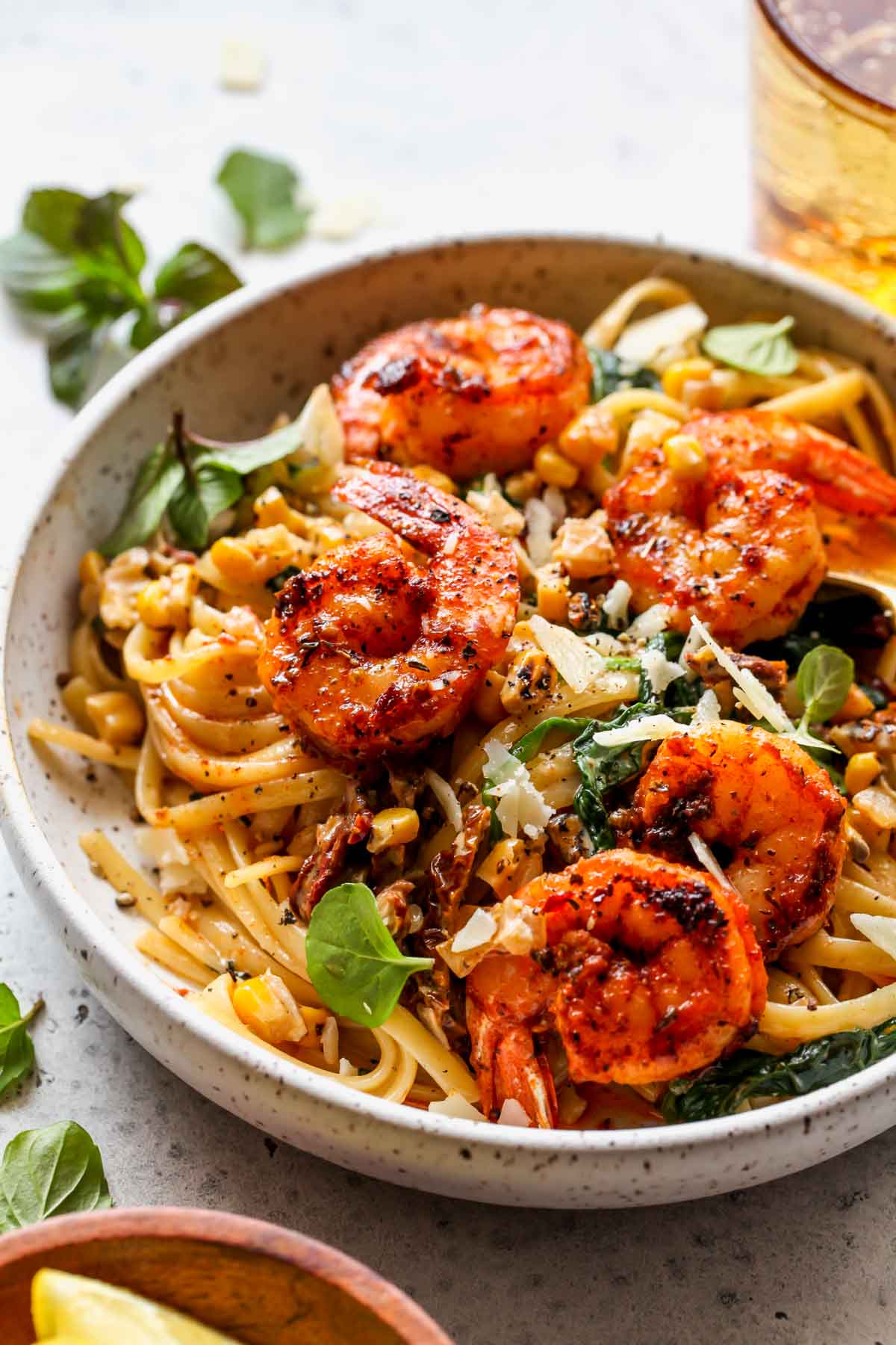 Creamy shrimp pasta with corn assembled in a white bowl