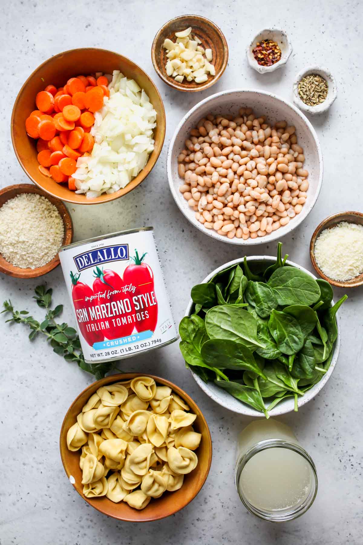 Recipe ingredients in separate bowls displayed on a white board.