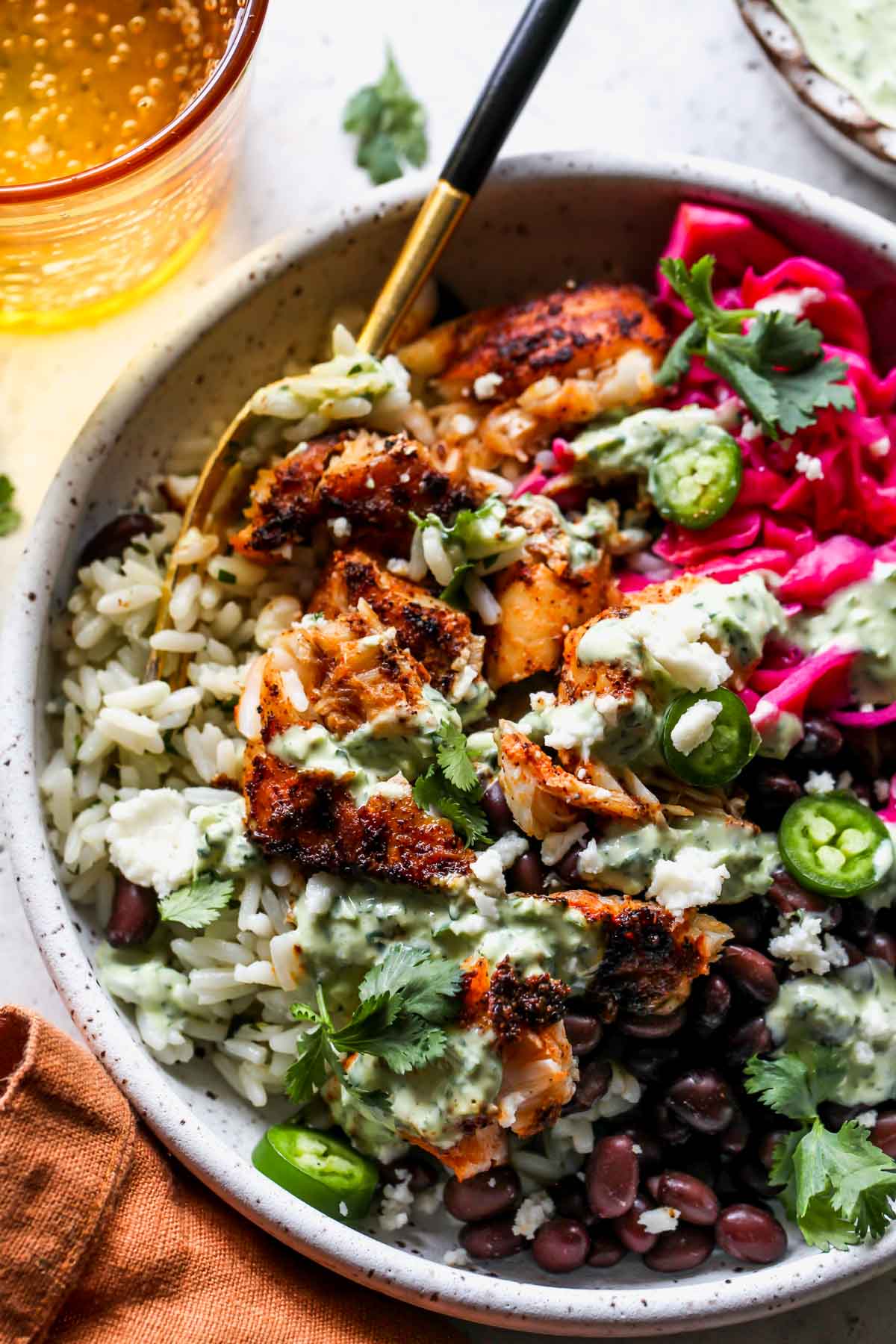 A fork taking a bite out of a fish taco bowl