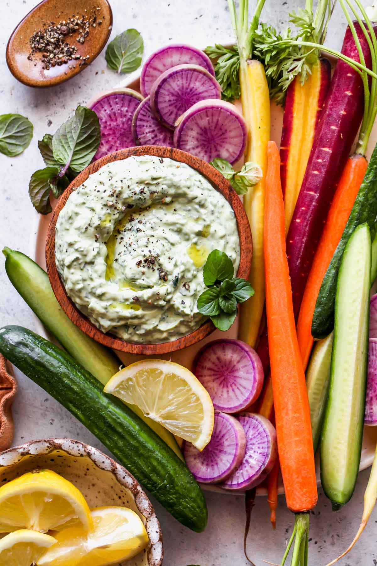 Tray of crudités with a bowl of green goddess dip in the center