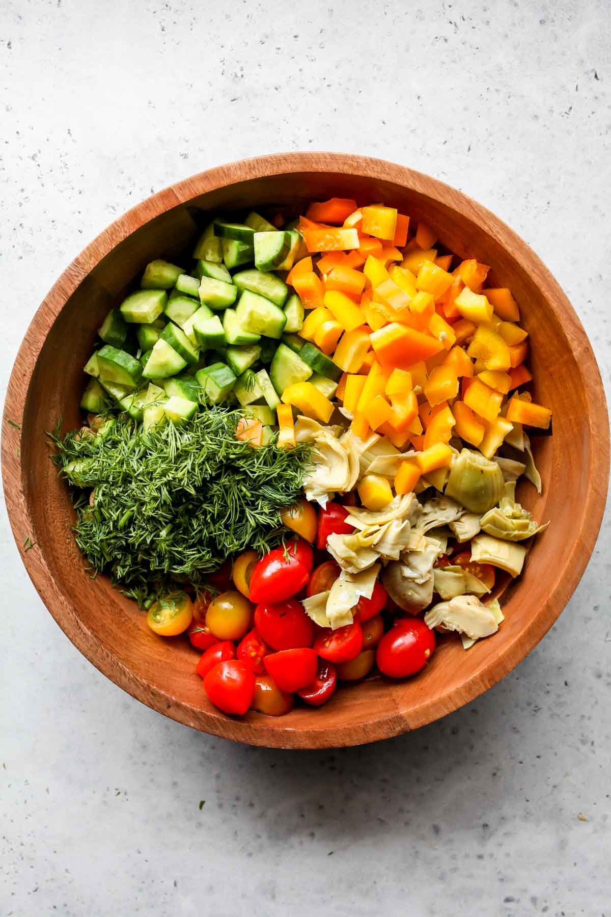 Chickpeas, tomatoes, cucumber, pepper, and artichoke in a large bowl
