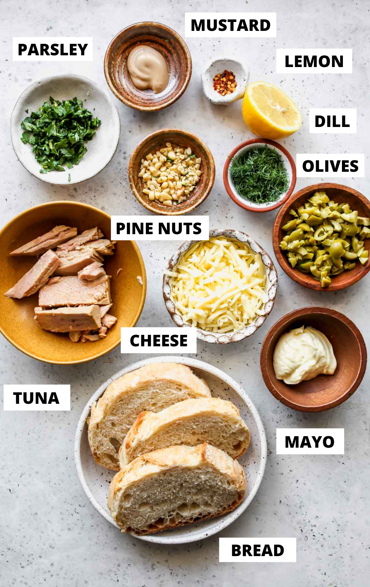 Recipe ingredients in separate bowls on a grey board with labels
