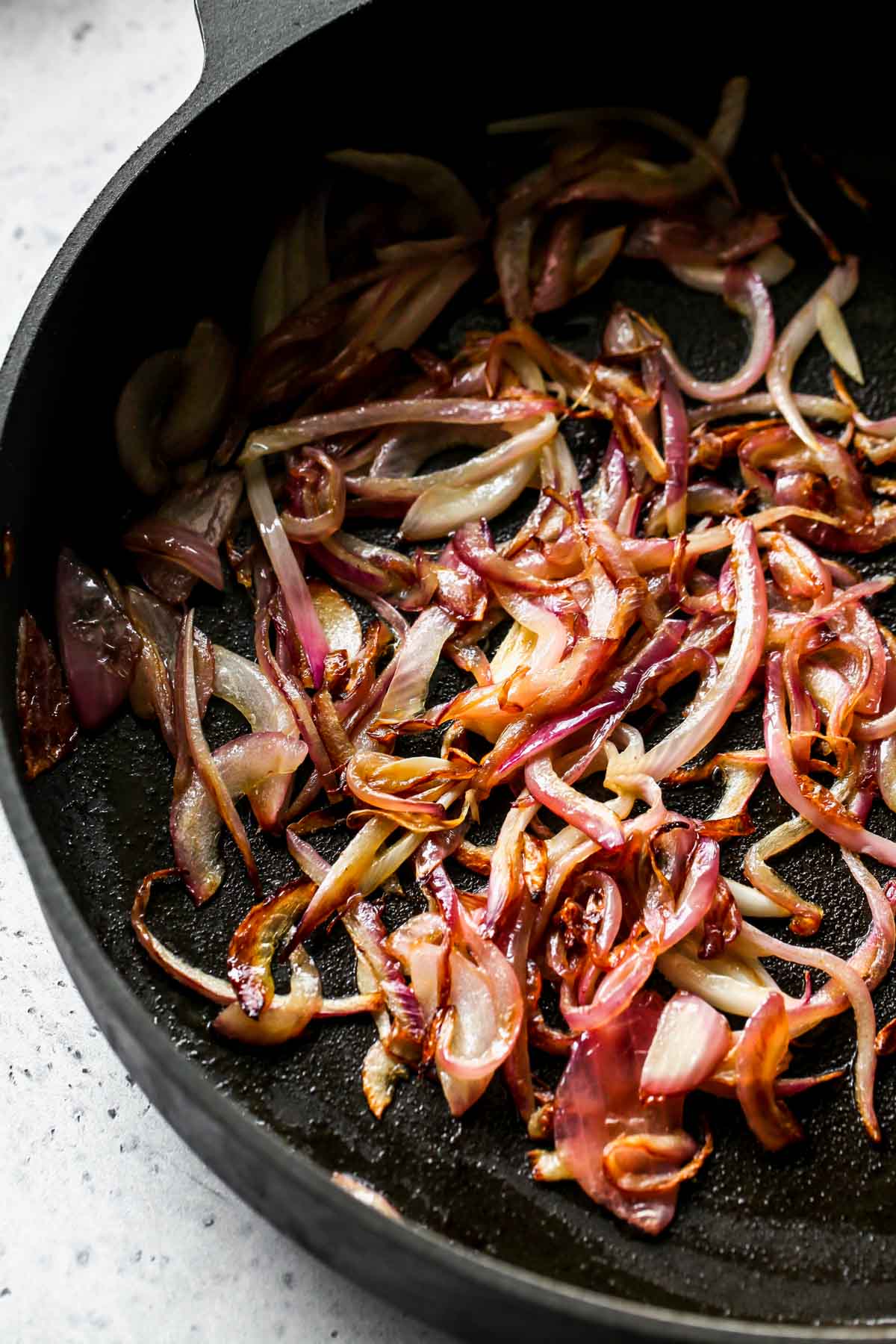 Red onions being sautéed in a skillet