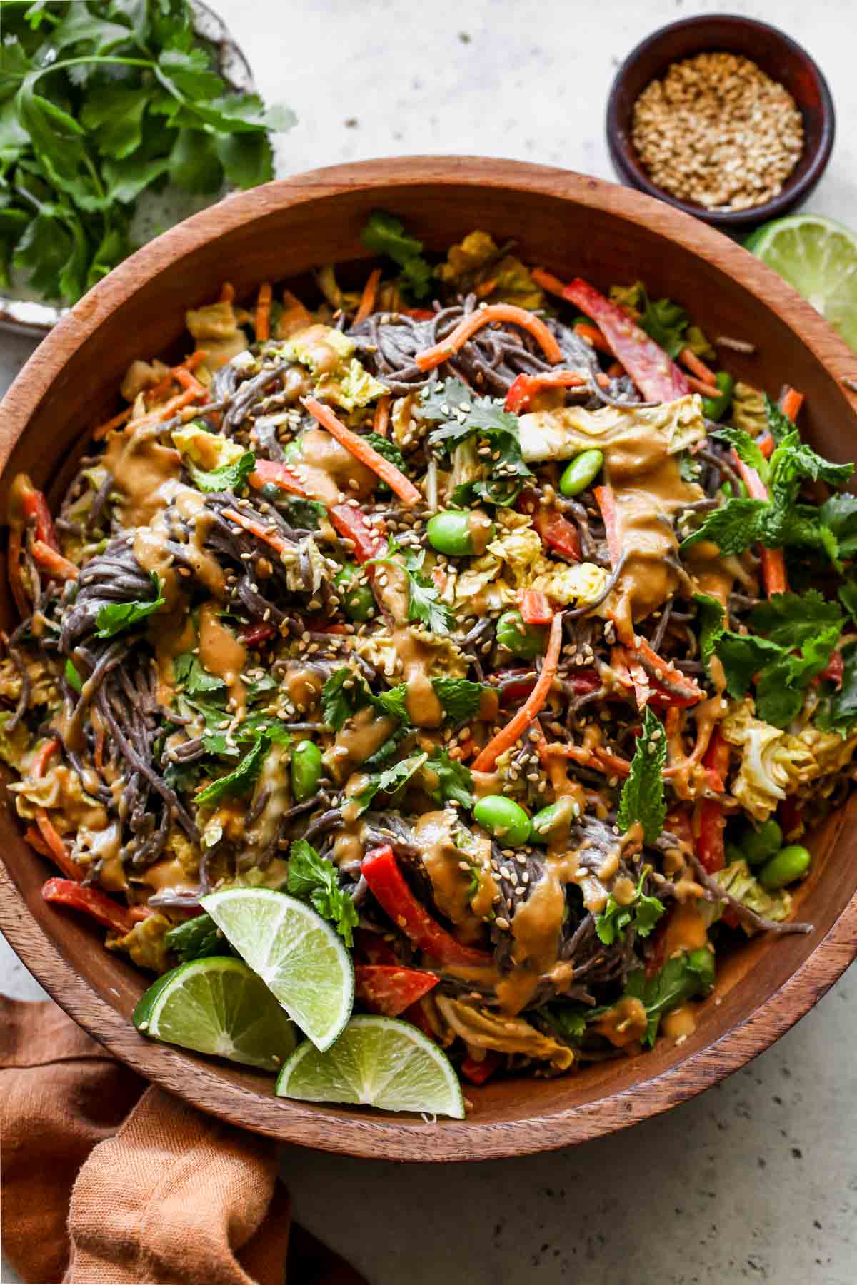 Soba salad with veggies and cashew sauce styled in a wooden serving bowl