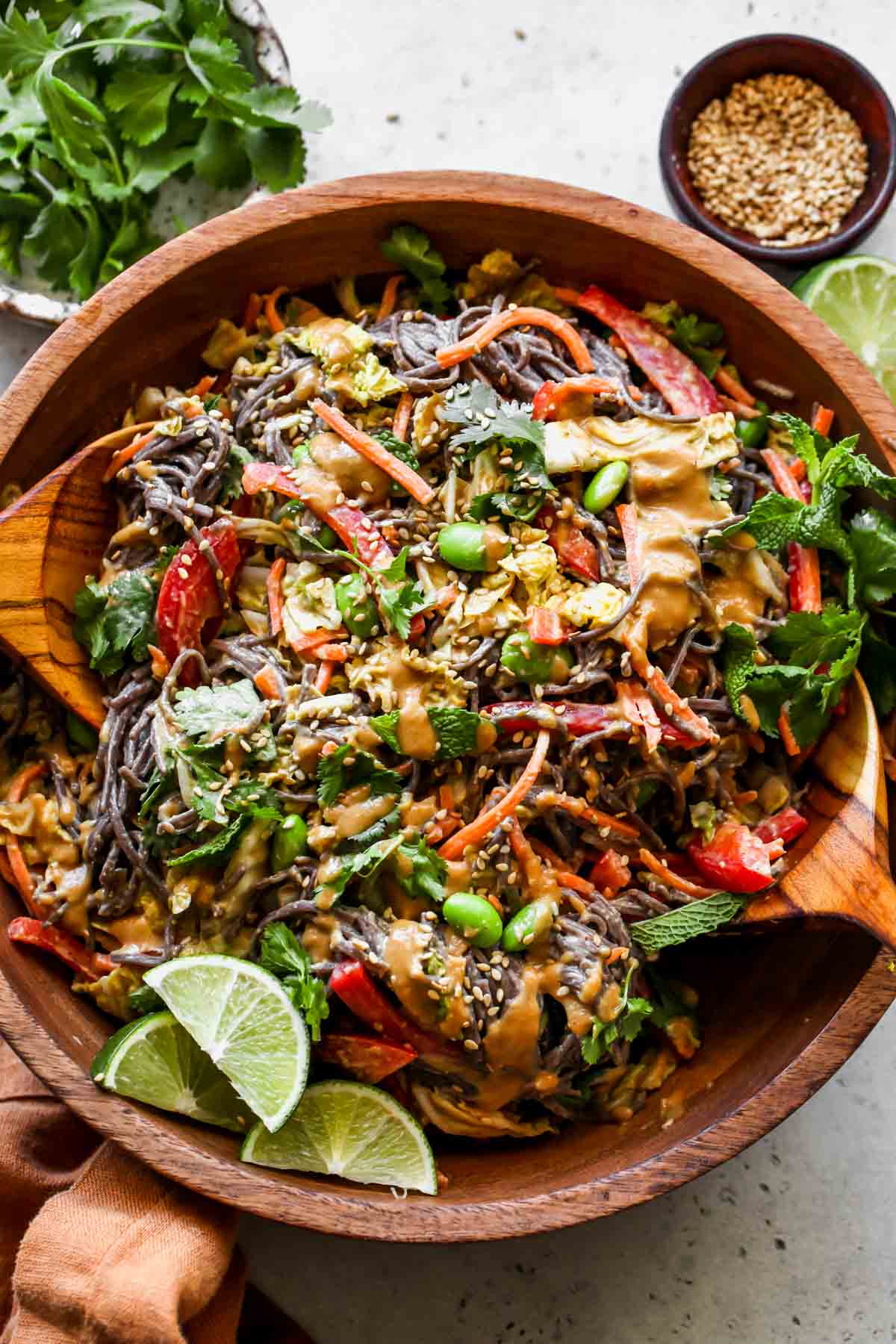 Soba noodle salad tossed in cashew dressing in a wooden serving bowl