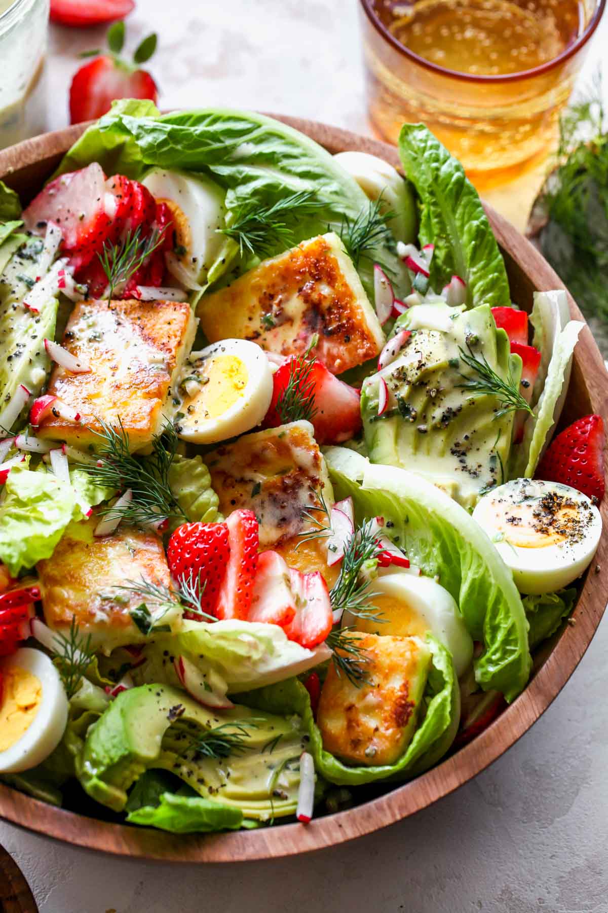 Cobb salad with strawberries, eggs, and avocado styled in a serving bowl
