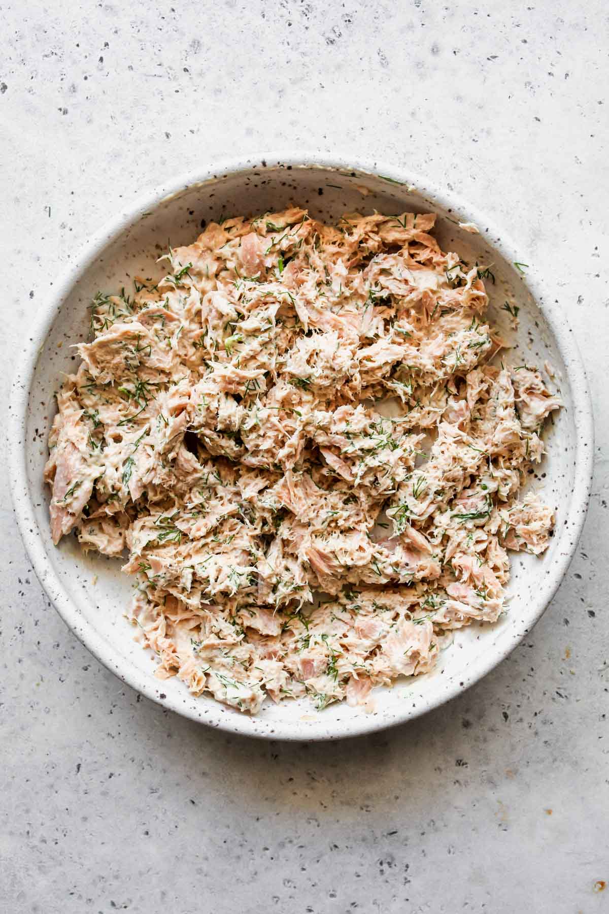 tuna salad being mixed in a white bowl