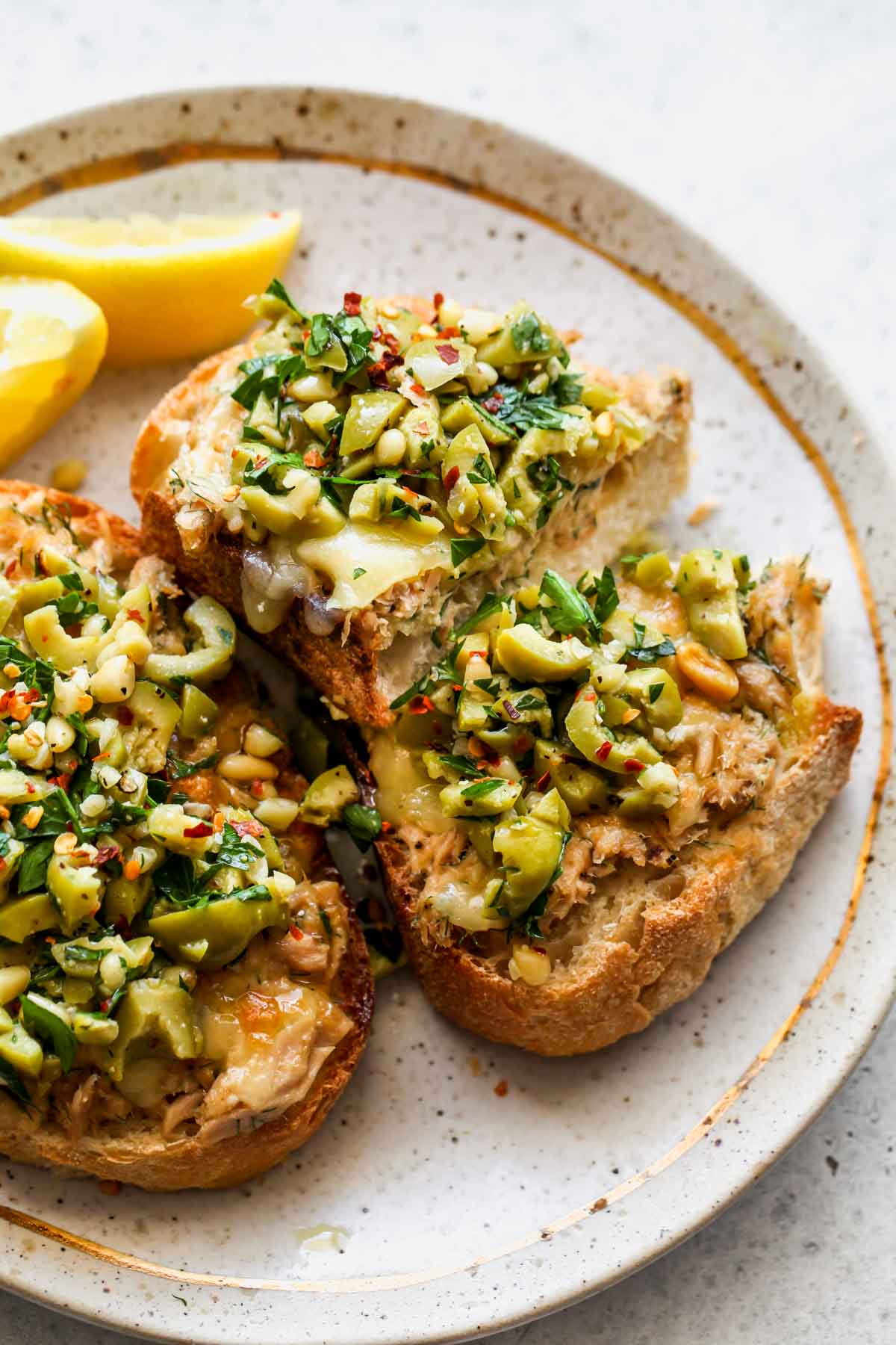 Cheesy tuna toast sliced in half on a plate