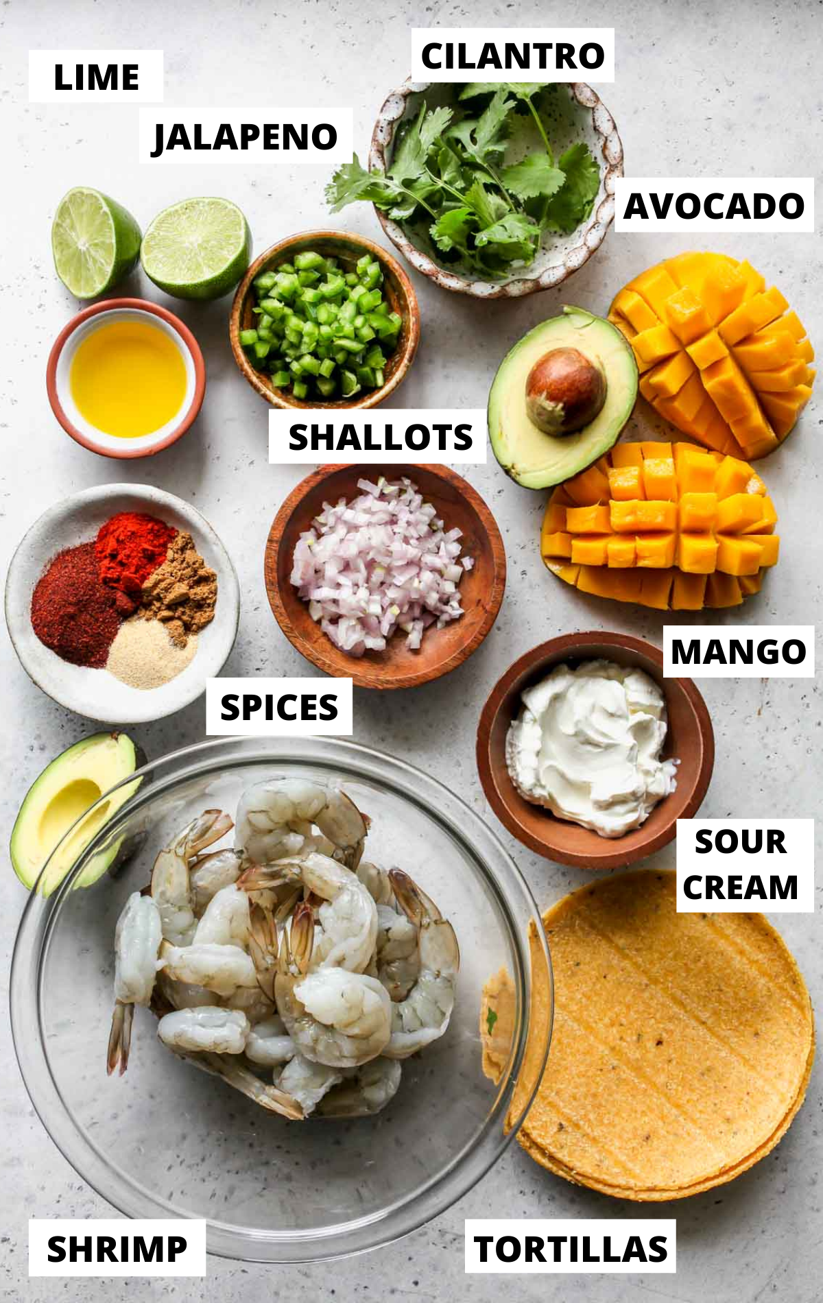Recipe ingredients in separate bowls on a grey board with labels
