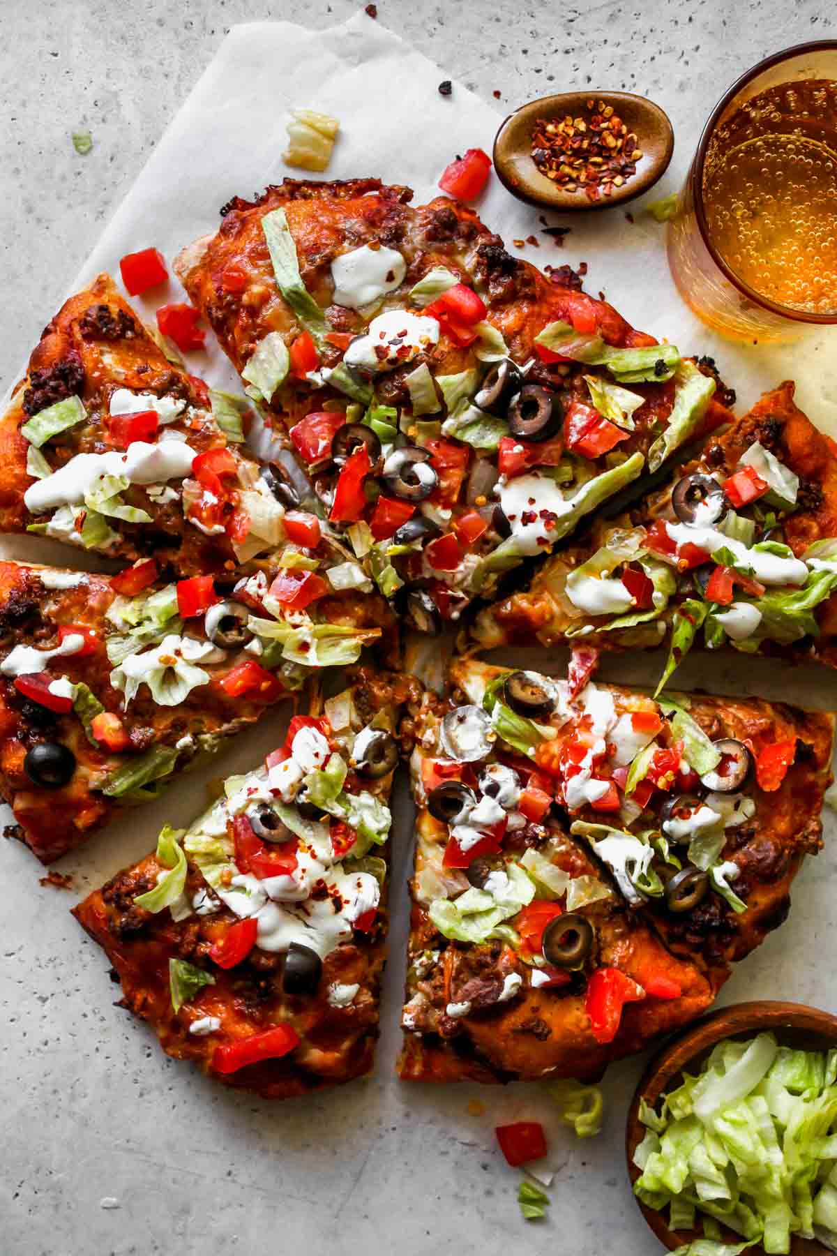 Taco Pizza sliced into 8 pieces on a serving board
