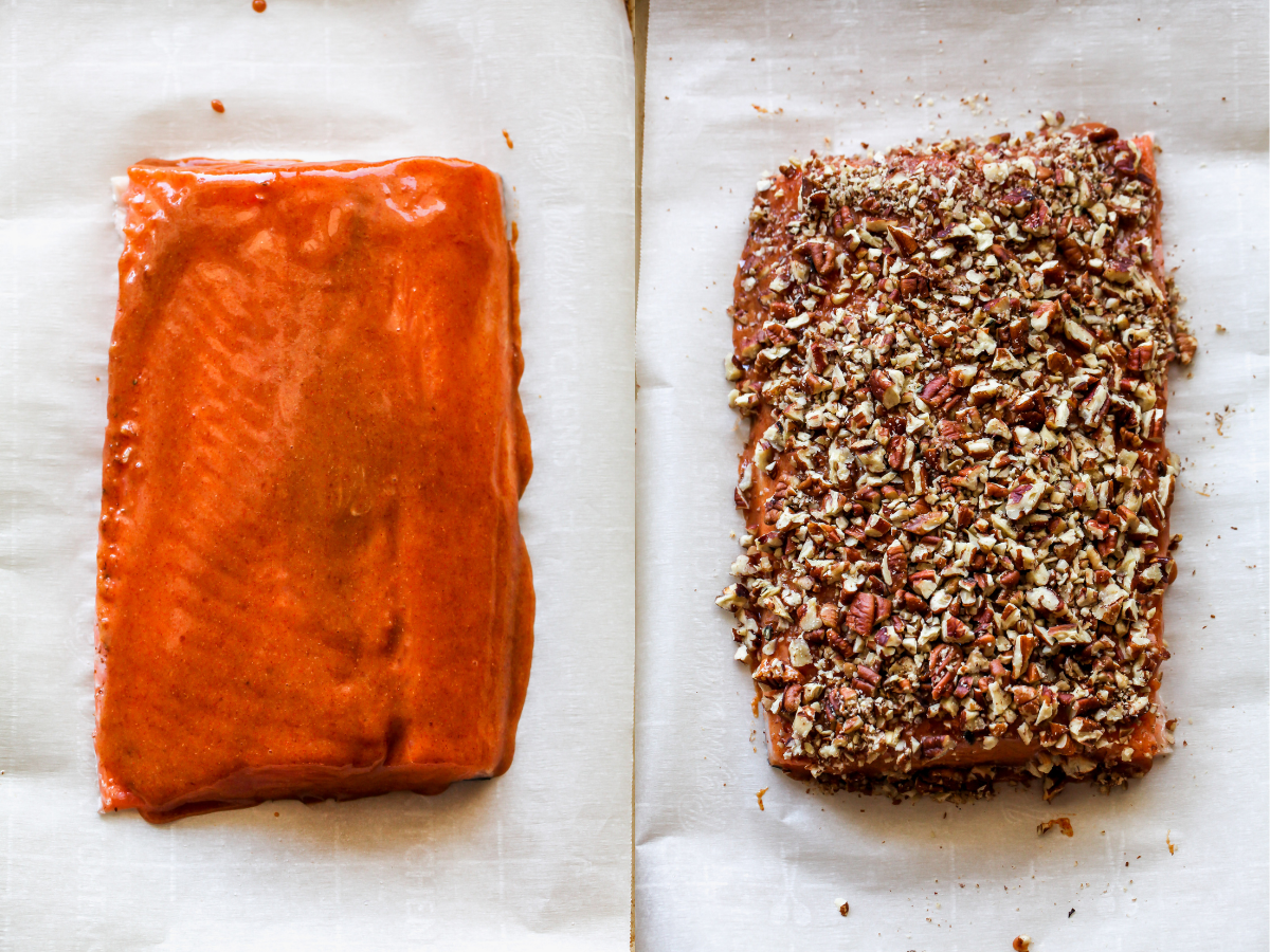 Salmon fillet being coated with Dijon, honey, and crushed pecans
