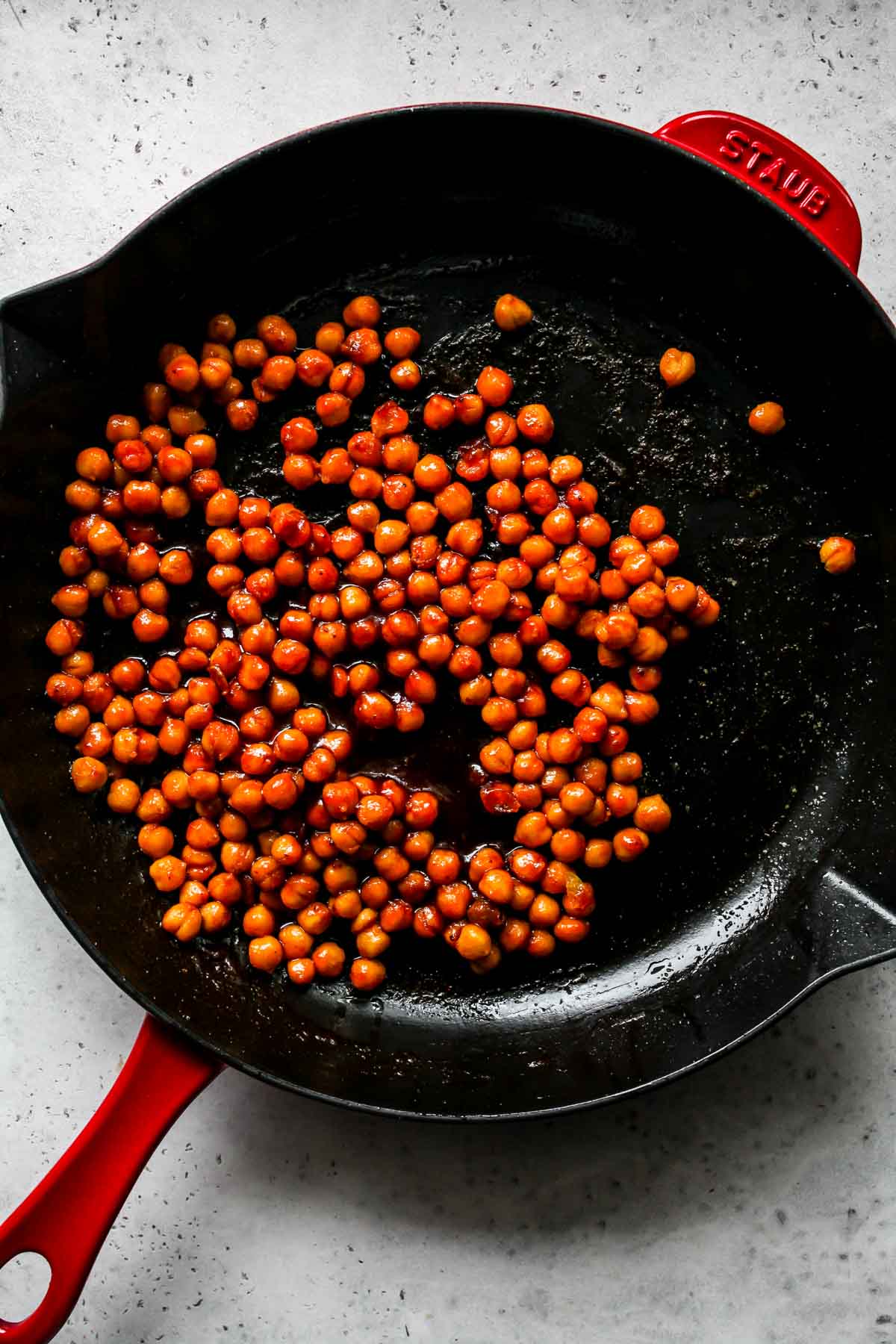 Chickpeas being sauteed in BBQ sauce in a pan