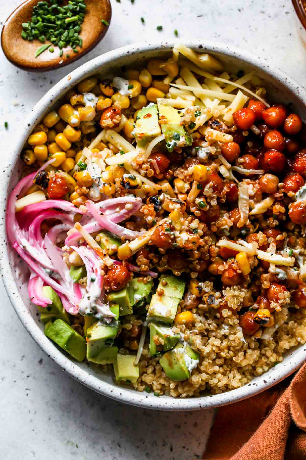 Chickpea quinoa bowl in a white serving bowl being mixed together