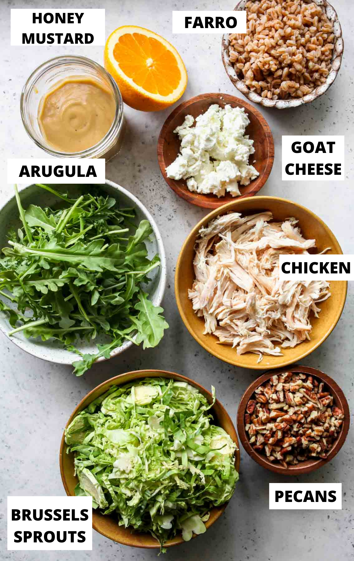 Recipe ingredients in separate bowls on a grey board with labels