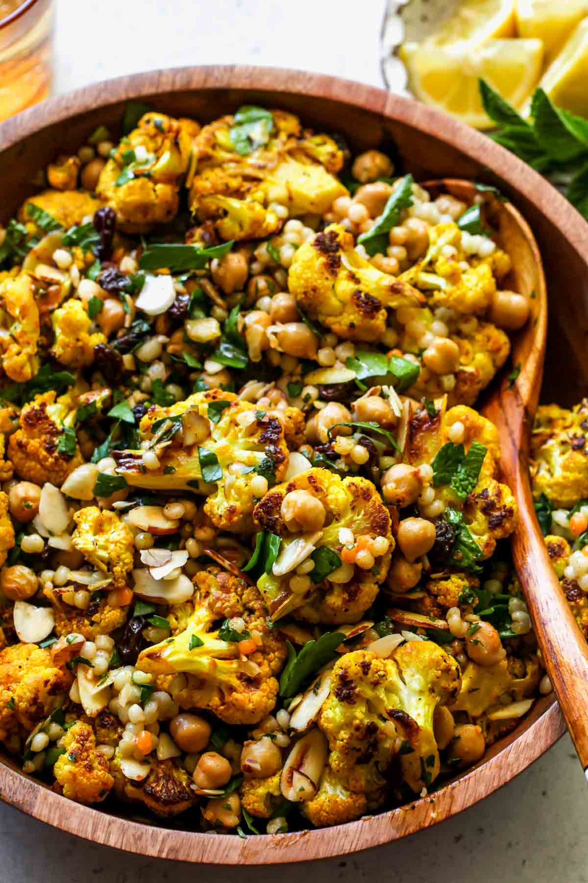 Moroccan Cauliflower and Couscous Salad being tossed with dressing in a large bowl