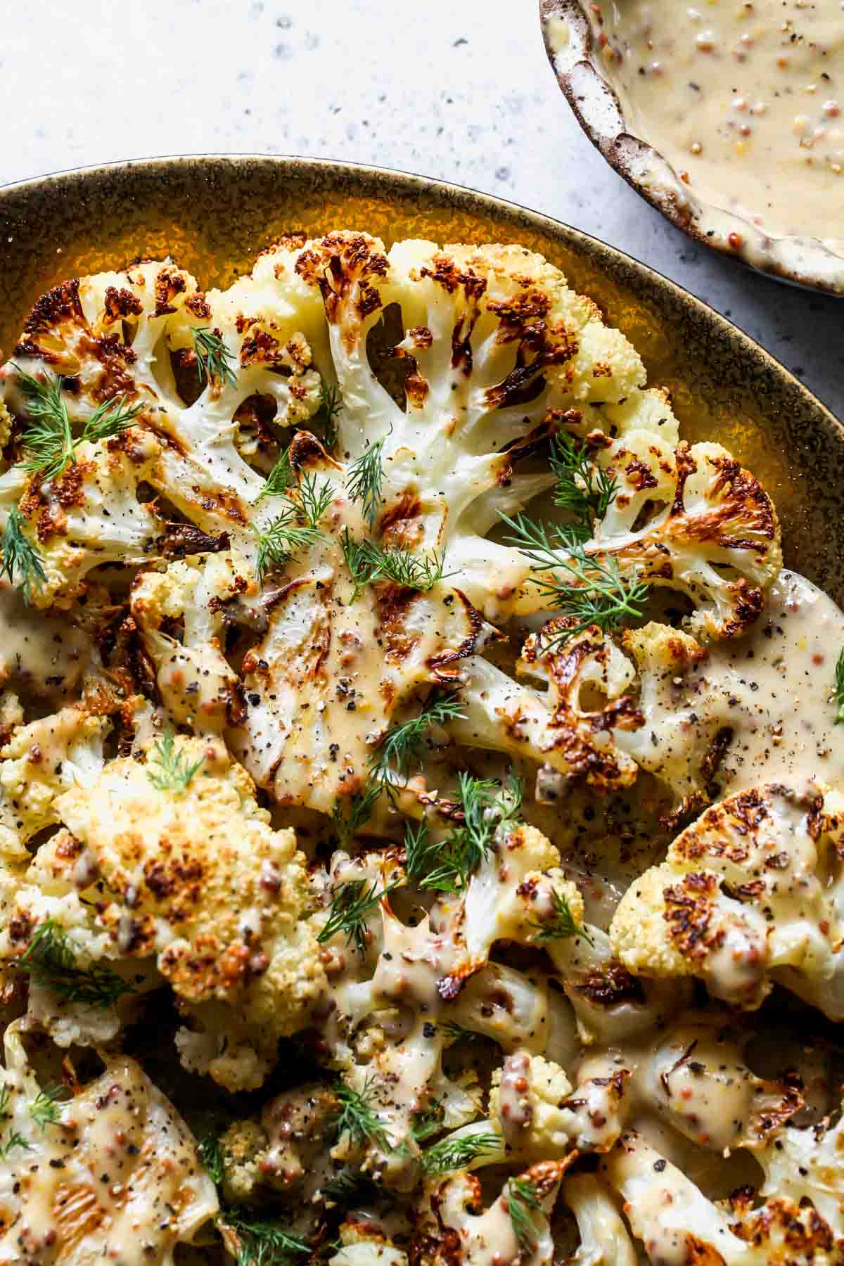 Cauliflower steak drizzled with maple-mustard sauce and herbs