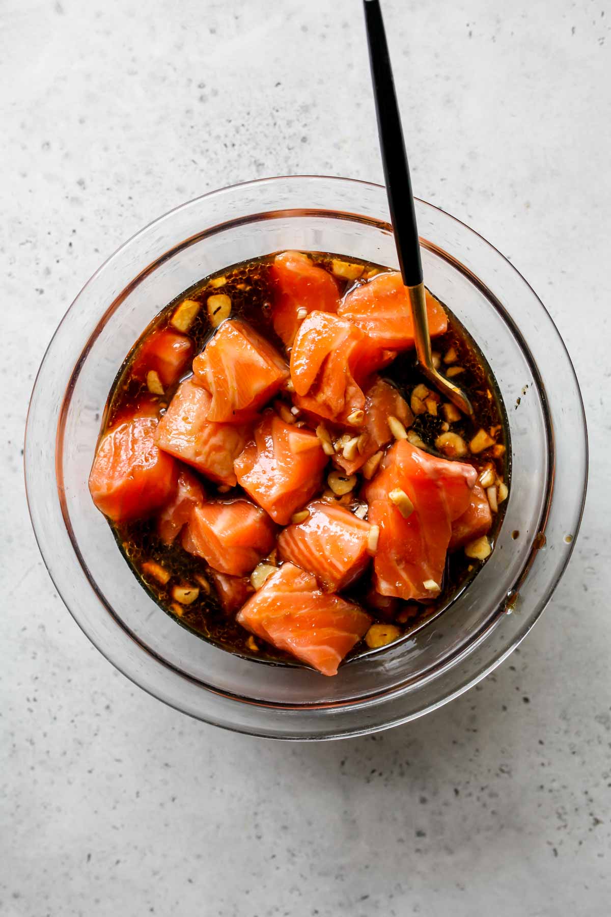 Chunks of salmon being marinated in teriyaki sauce