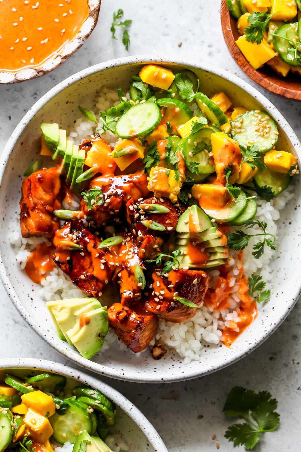 Salmon sushi bowl with cucumber-mango salsa and aioli in a white bowl