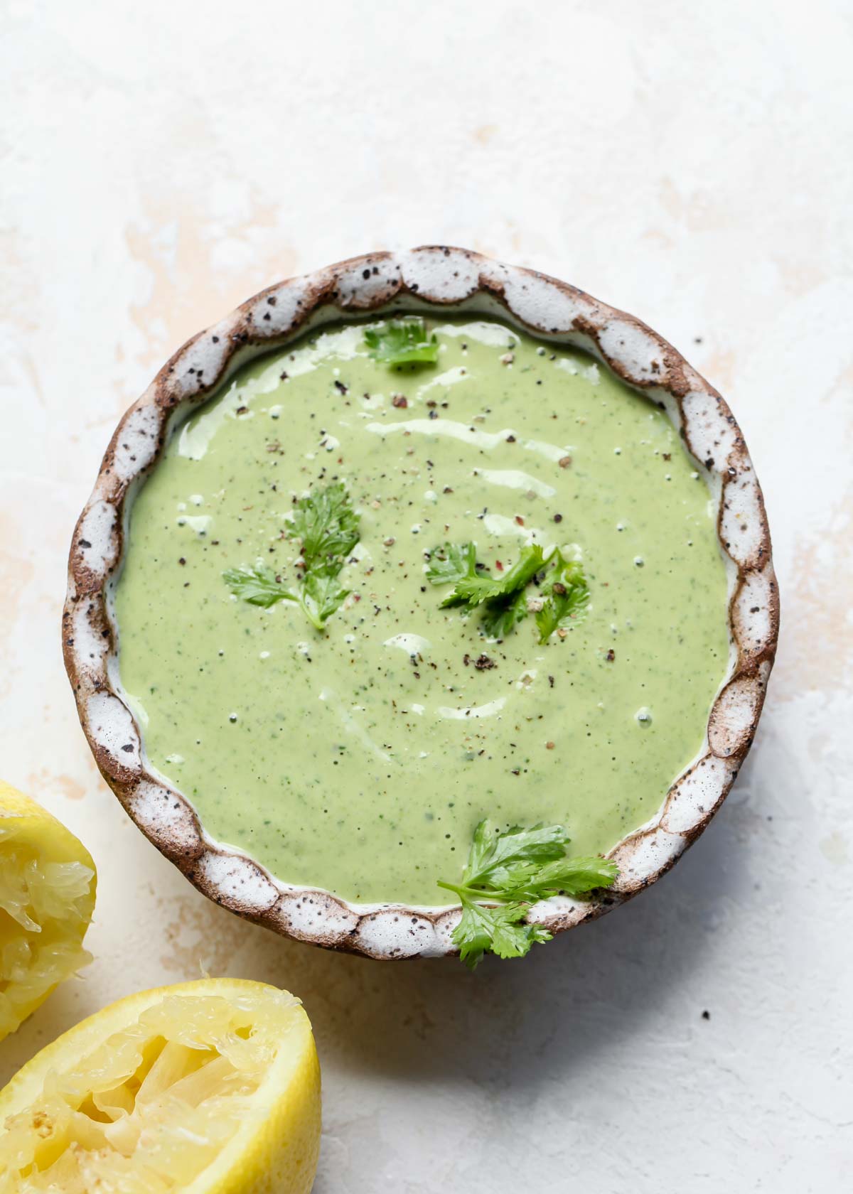 Green tahini sauce in a white bowl