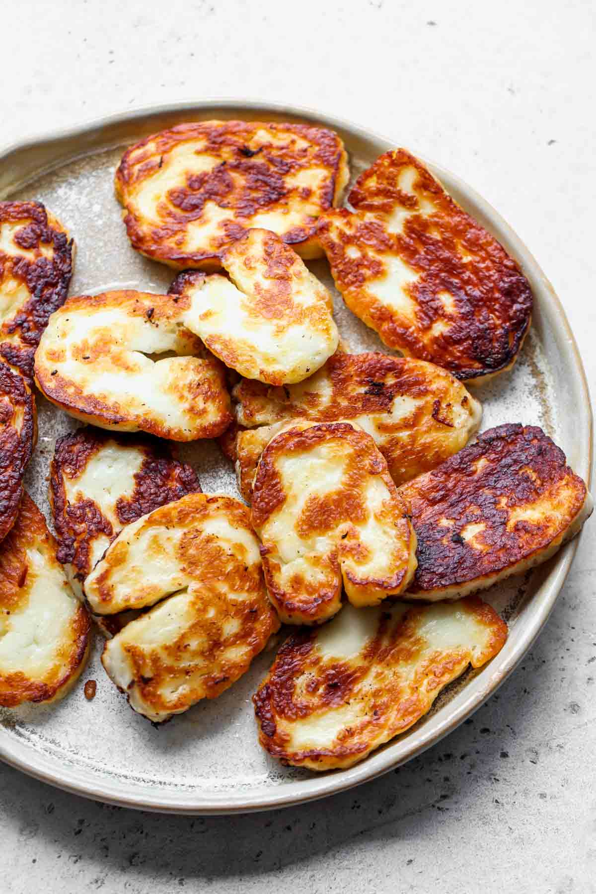 Seared slices of halloumi cheese arranged on a plate