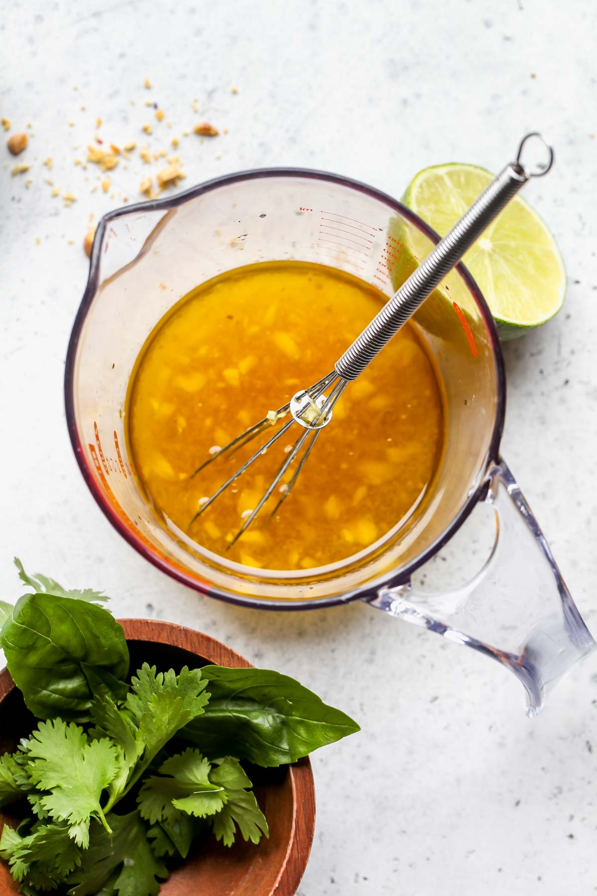 Honey-ginger dressing being whisked in a glass measuring cup