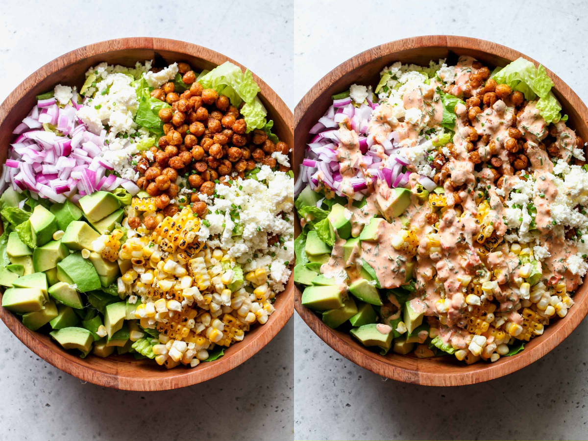 Romaine, chickpeas, avocado, and grilled corn being topped with harissa ranch dressing in a mixing bowl