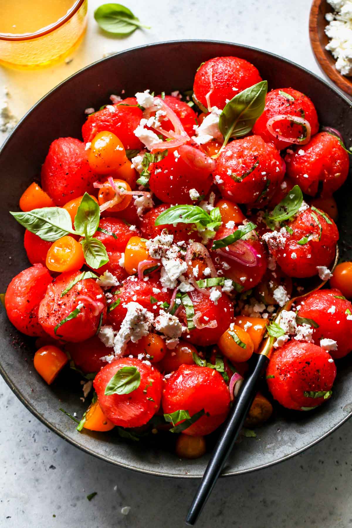Watermelon tomato basil salad in a gray serving bowl