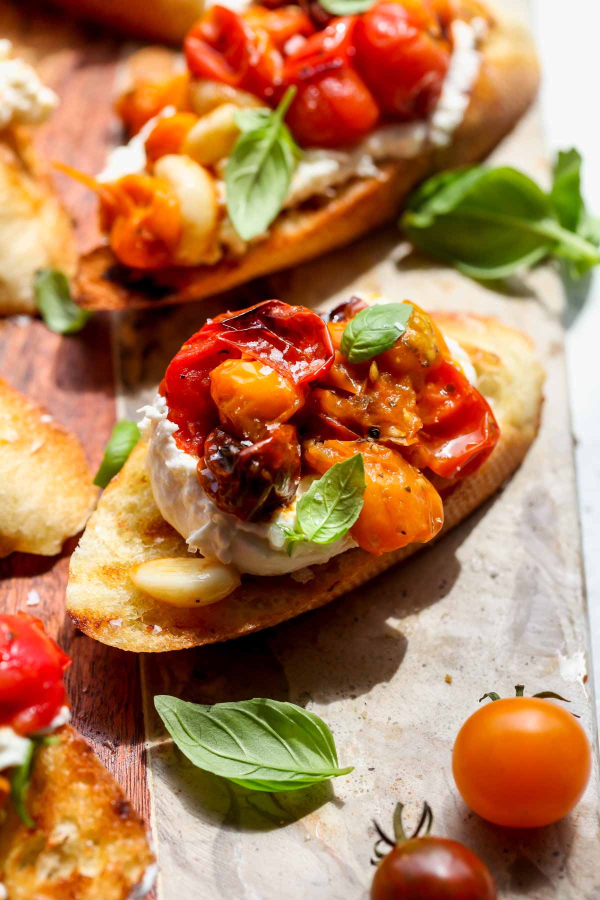 Cherry tomato burrata bruschetta arranged on a cutting board