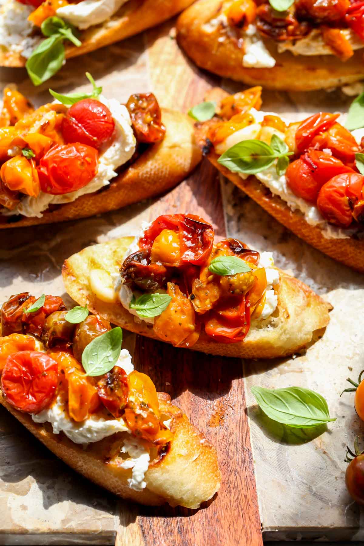 Burrata bruschetta being assembled on a cutting board