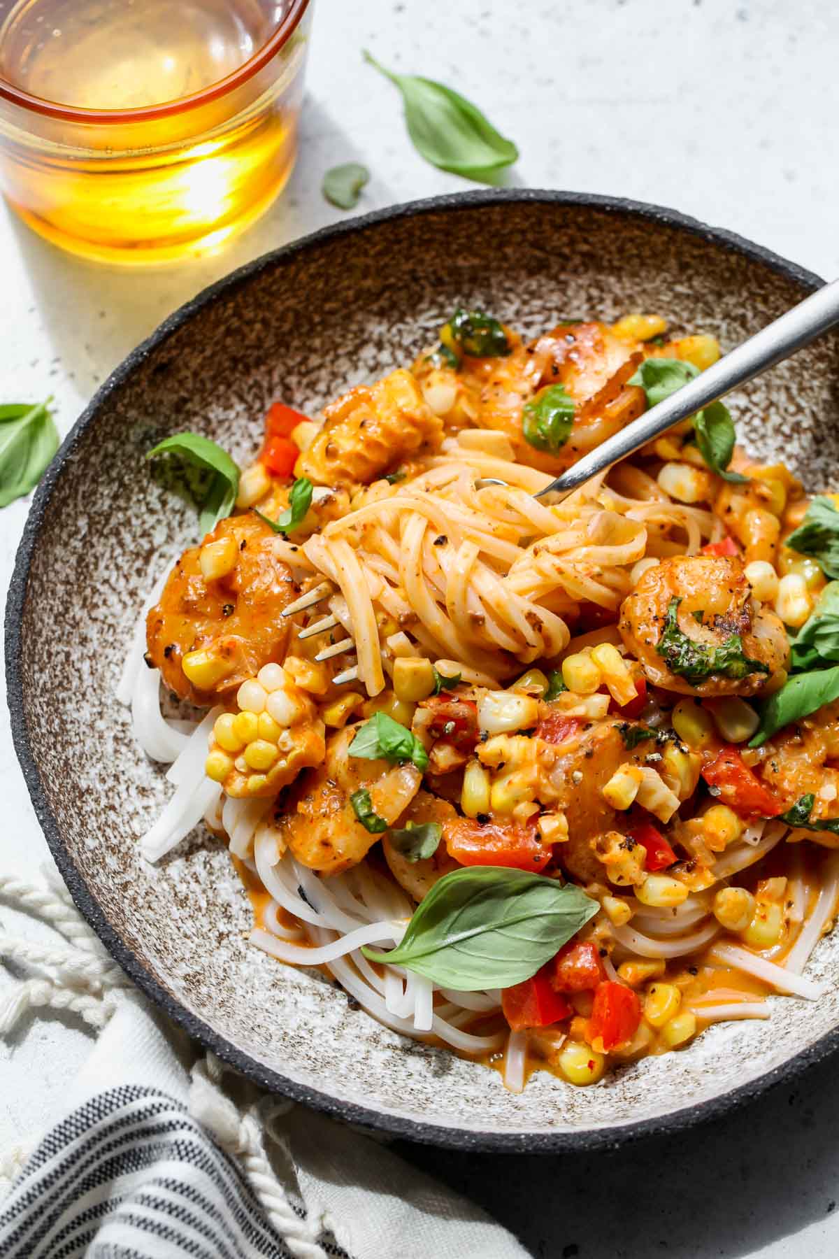 A fork twirling rice noodles coated in curry sauce
