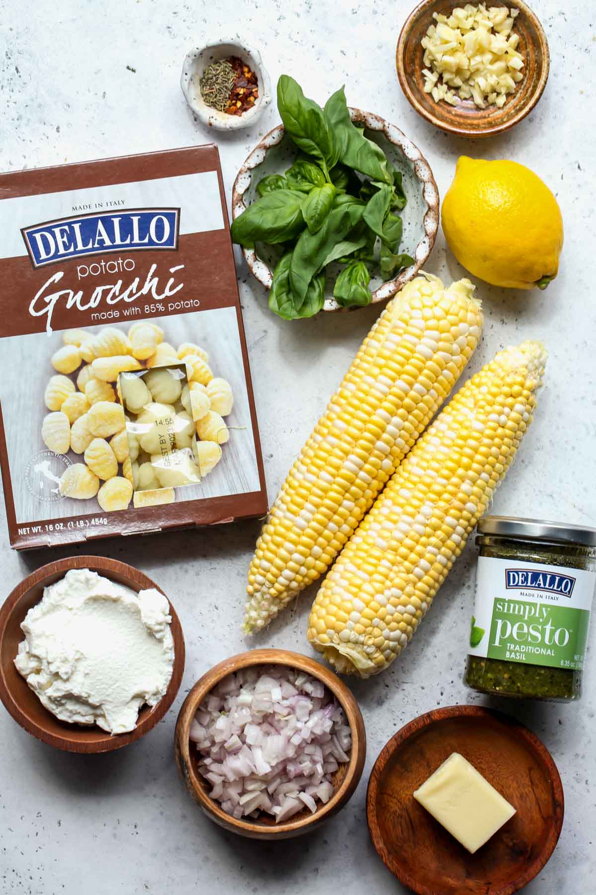 Gnocchi recipe ingredients in separate bowls on a gray surface