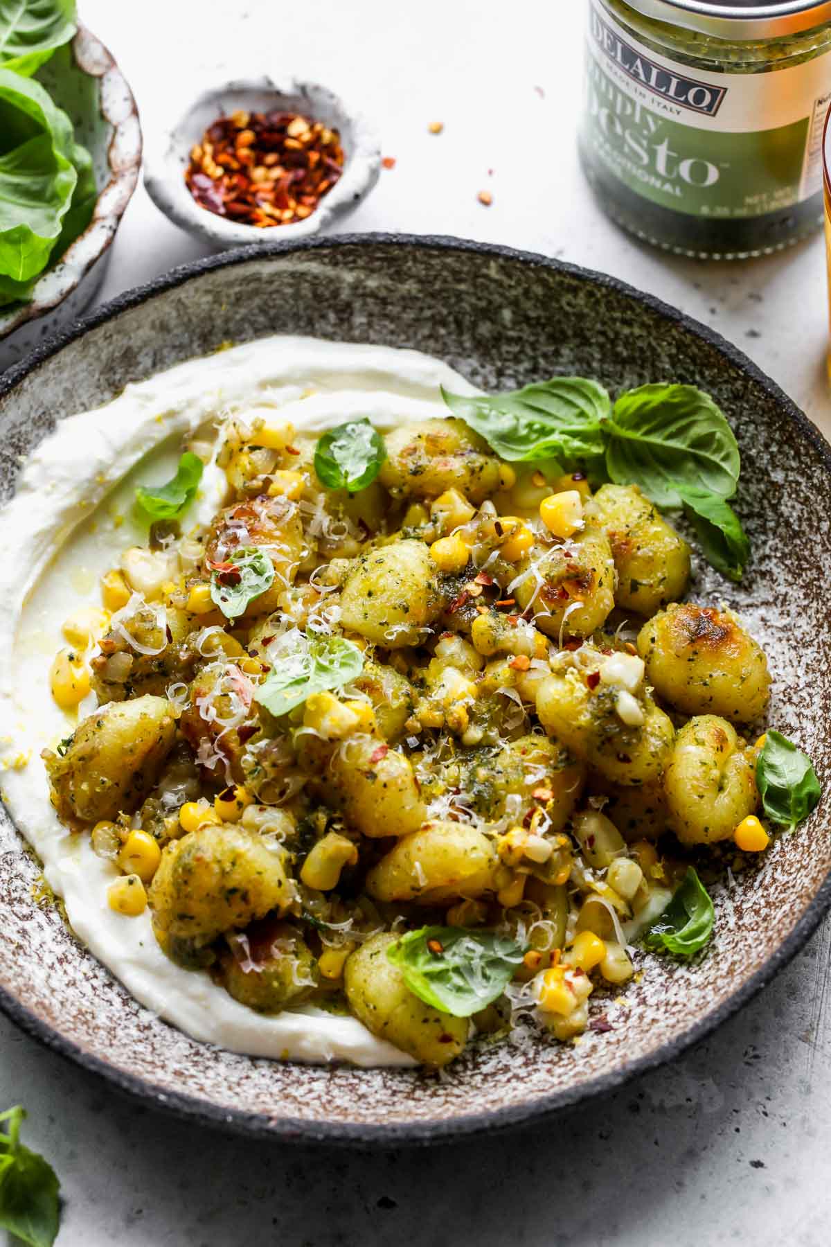 DeLallo pesto placed next to a bowl of styled gnocchi