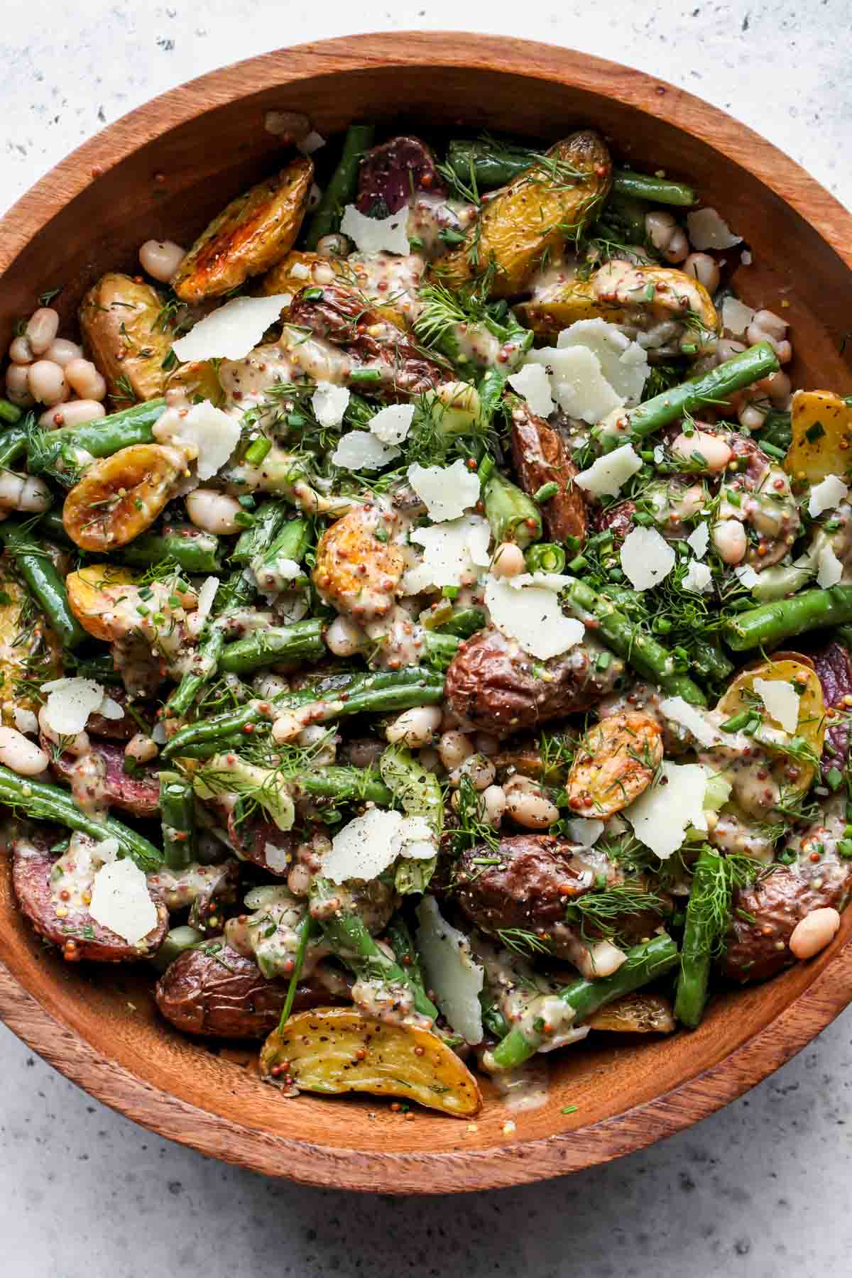 Roasted Potato Salad with green beans, parmesan, and mustard dressing in a wooden serving bowl
