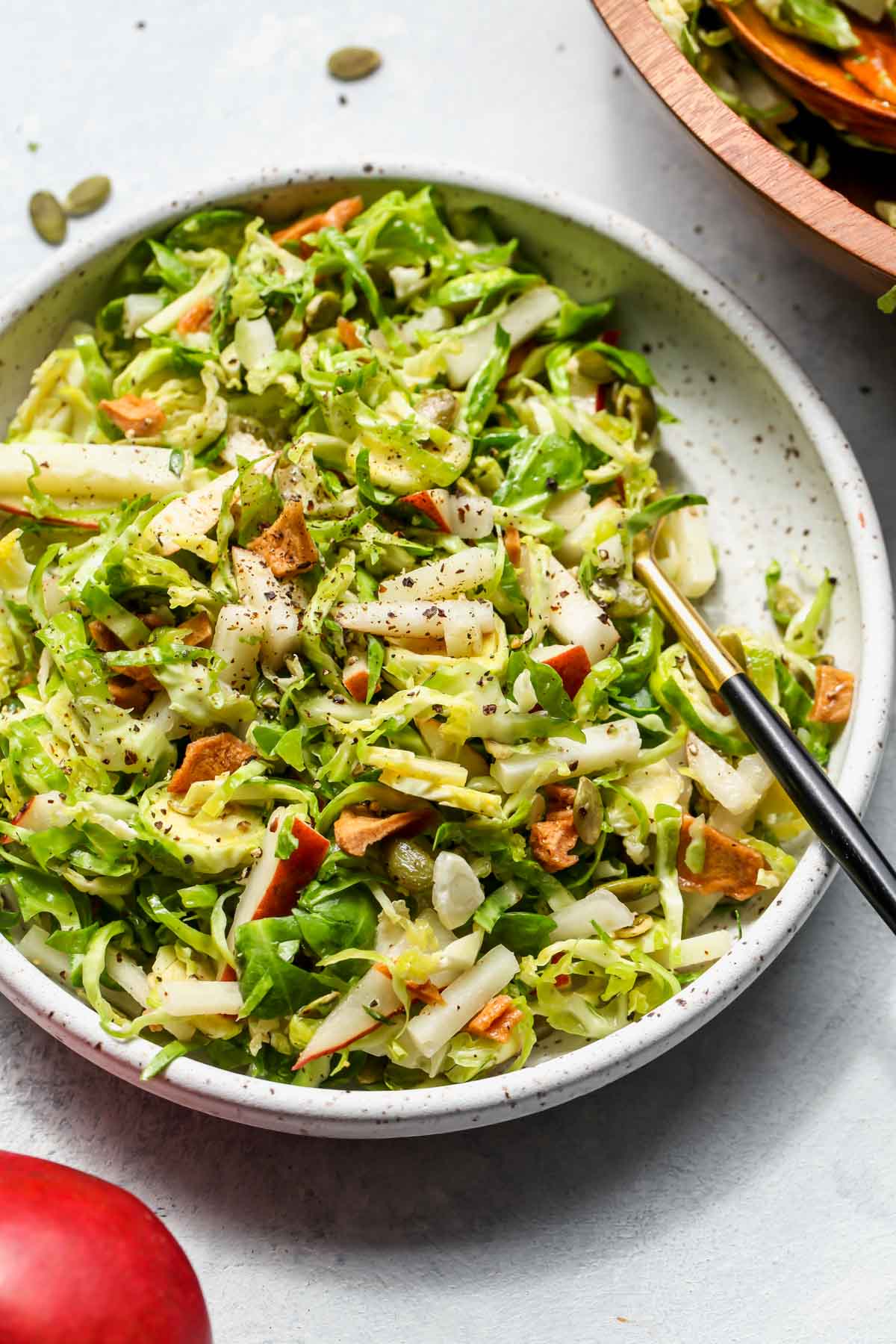 Single serving of brussels and pear salad in a white bowl