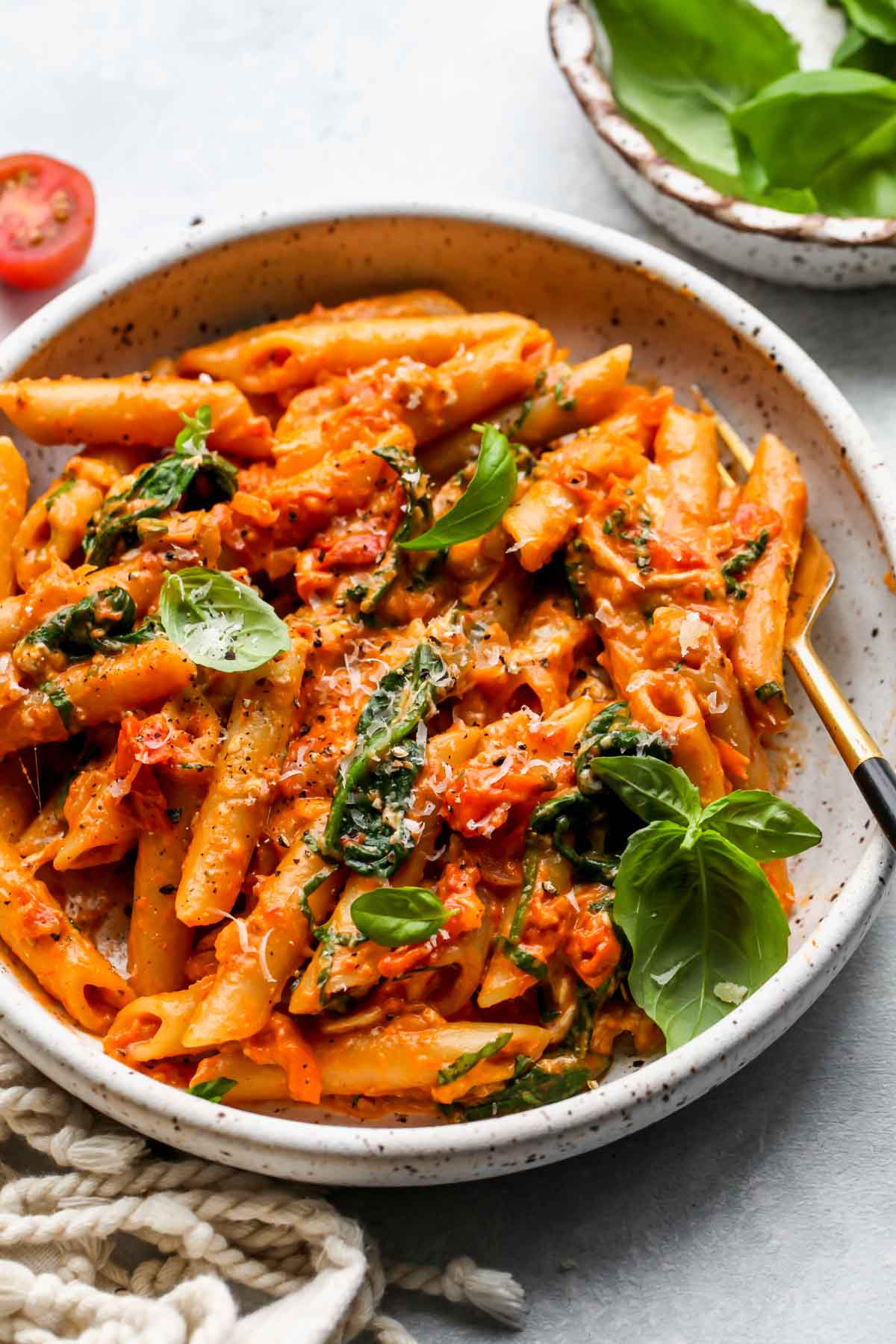Individual portion of creamy tomato pasta in a white bowl