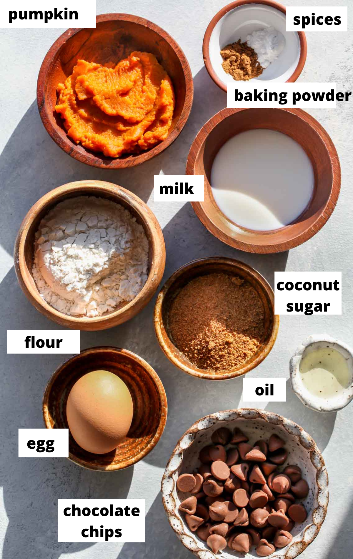Recipe ingredients in separate bowls on a blue board with labels.