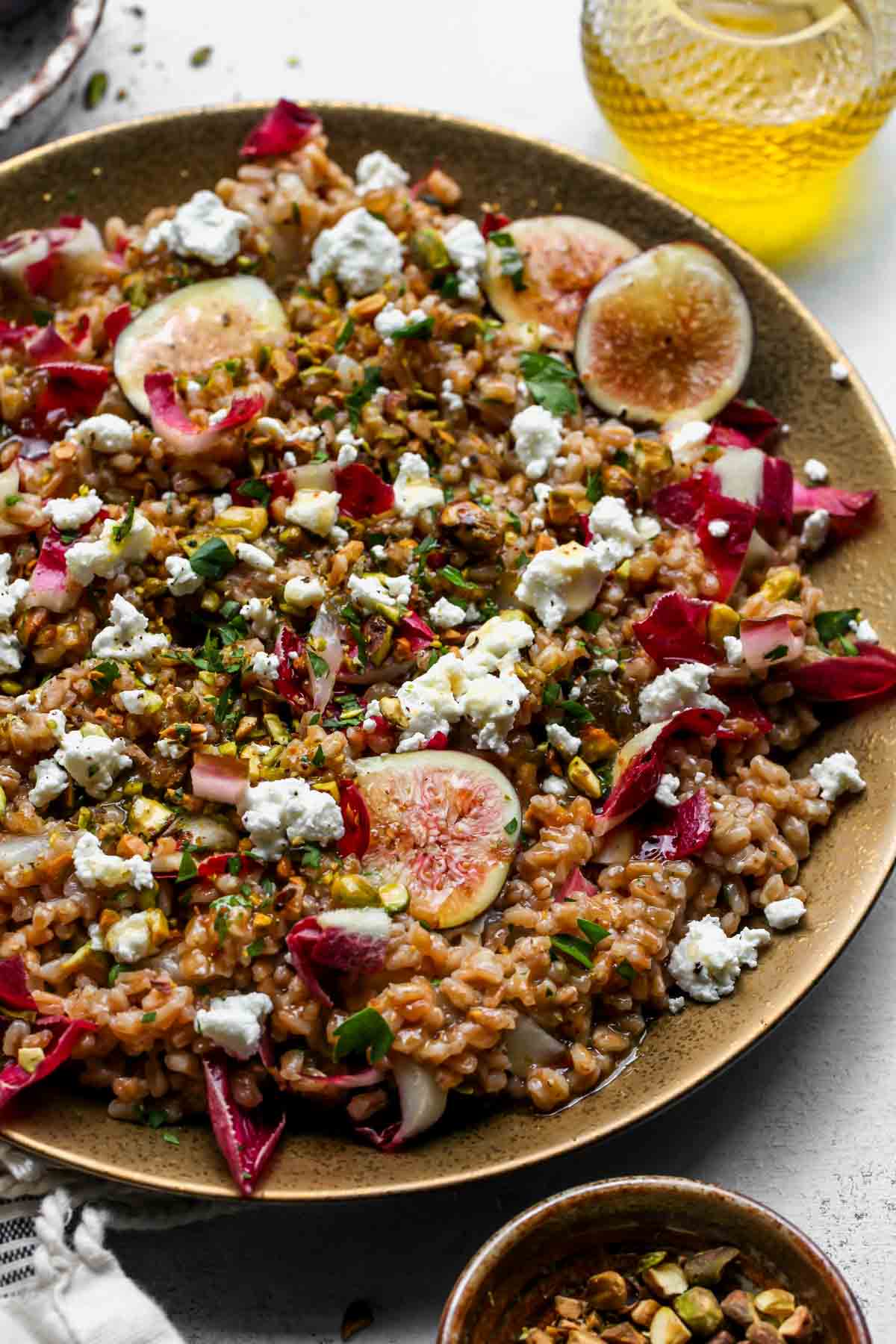 Warm farro salad topped with fresh figs assembled on a serving platter